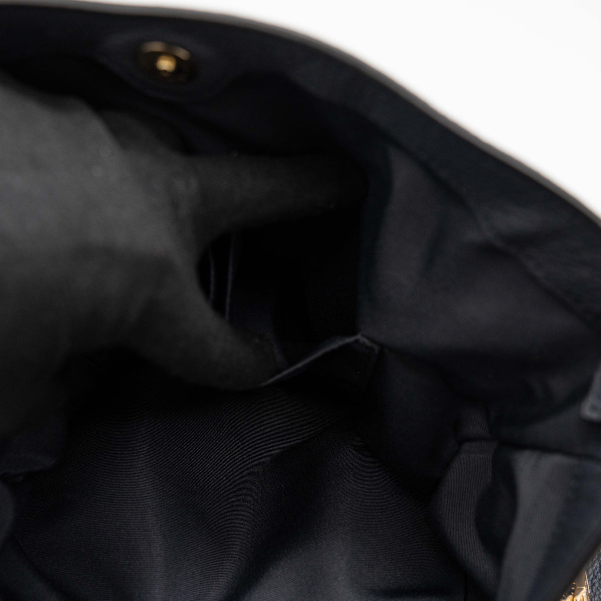 Coach Lexy Shoulder Bag in black pebbled leather with gold-tone hardware and double handles, styled against a white background.