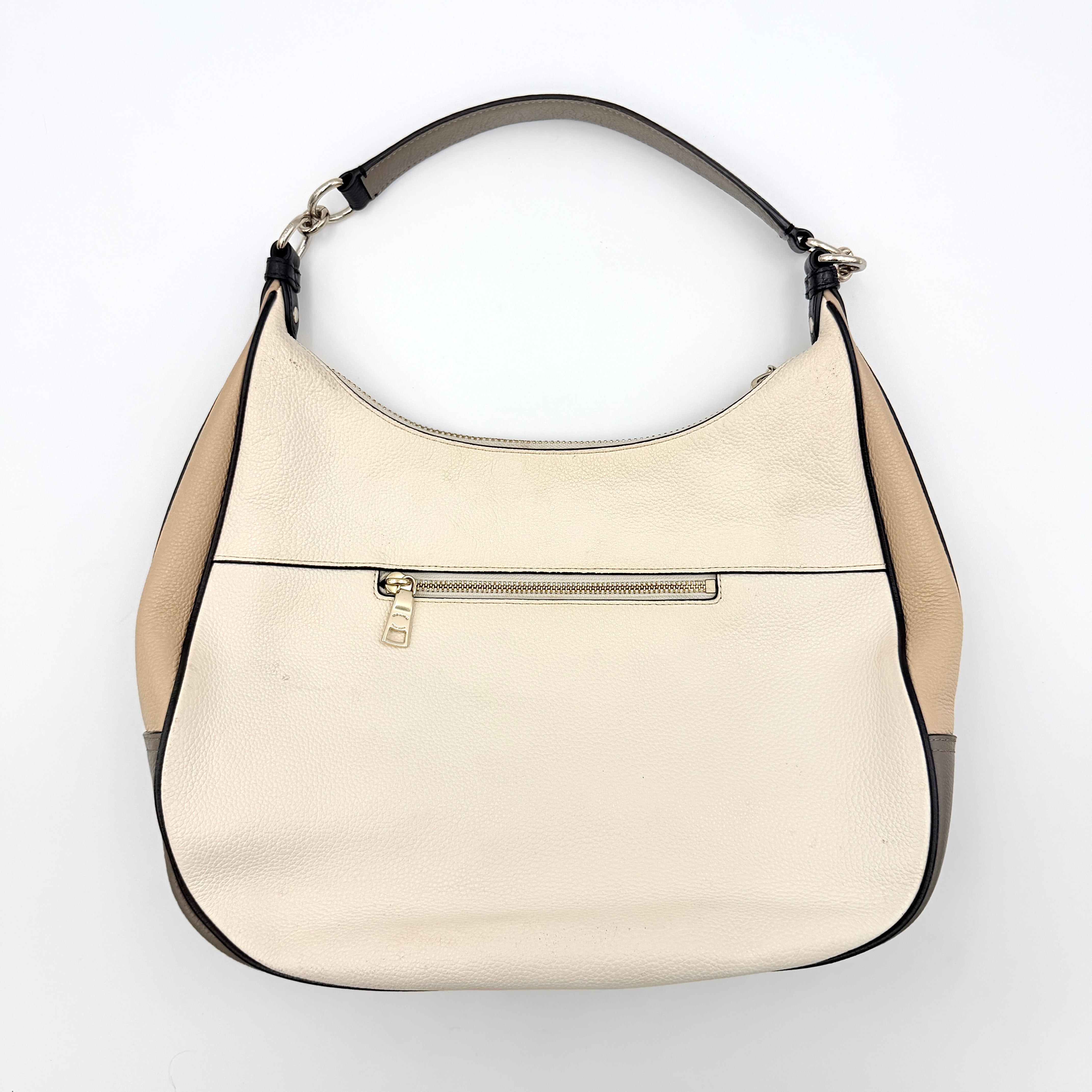 Coach Harley East West Hobo in cream and beige pebbled leather with a sculpted silhouette, black piping, and silver hardware.