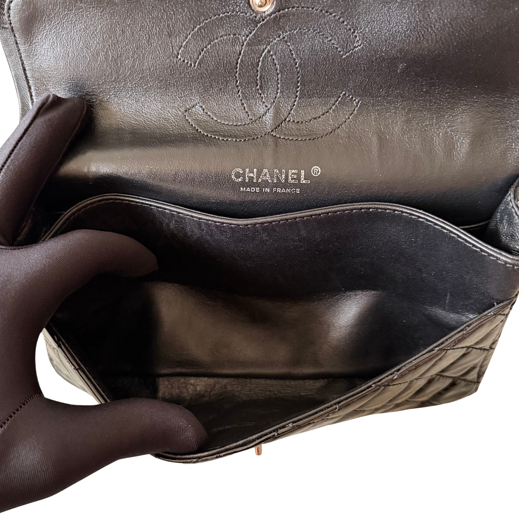 Chanel 25 Matelasse Double Flap bag in glossy black patent leather with silver-tone hardware and quilted finish.