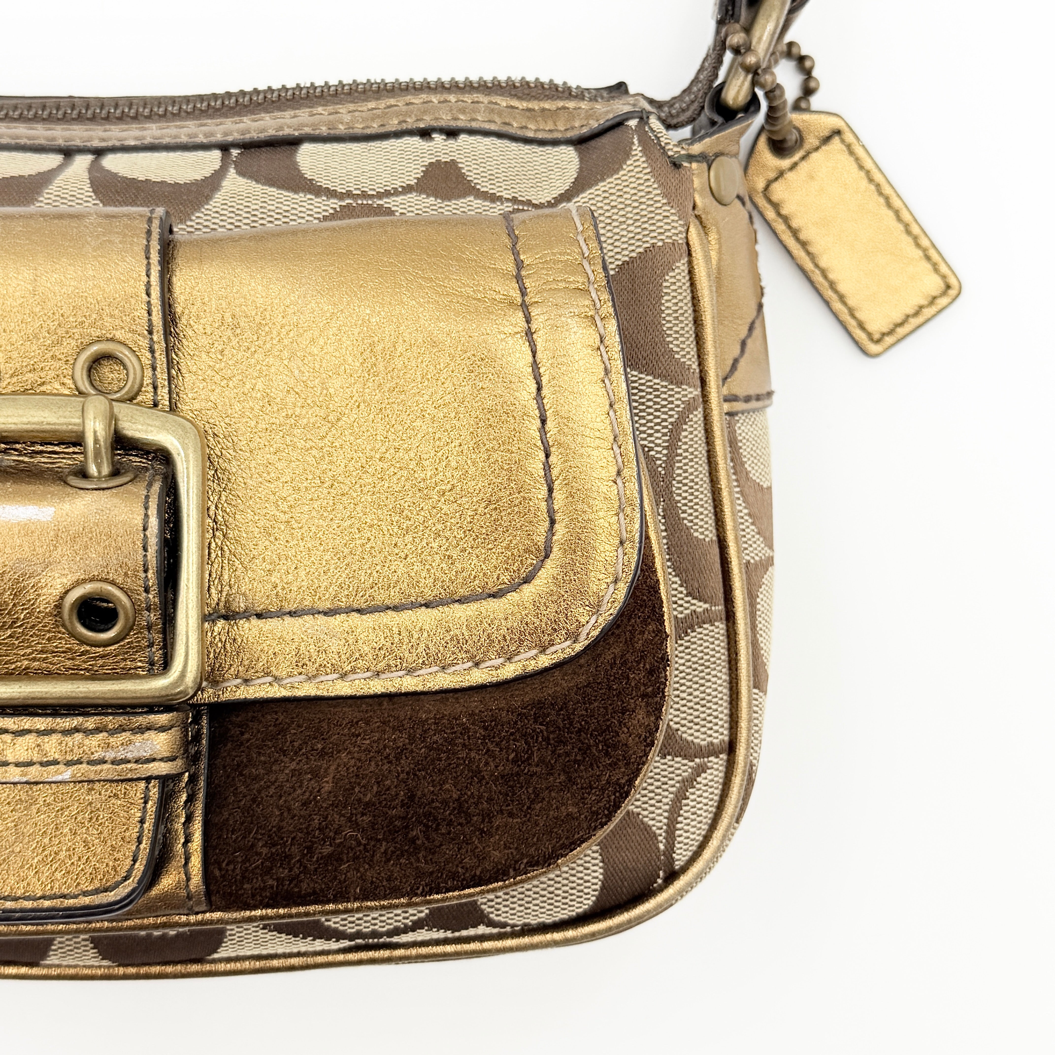 Coach Signature shoulder bag in beige jacquard with gold leather front flap, showcased on a plain background.