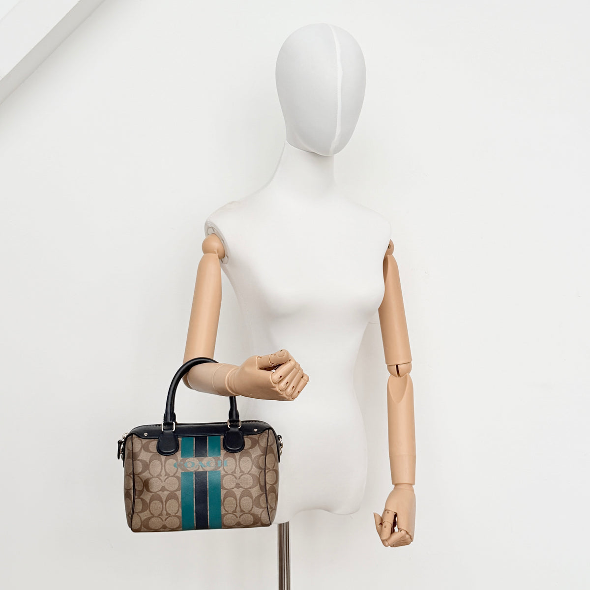 Coach Signature Mini Bennett Boston Bag in monogram canvas with navy and teal varsity stripes and dark navy leather trim.