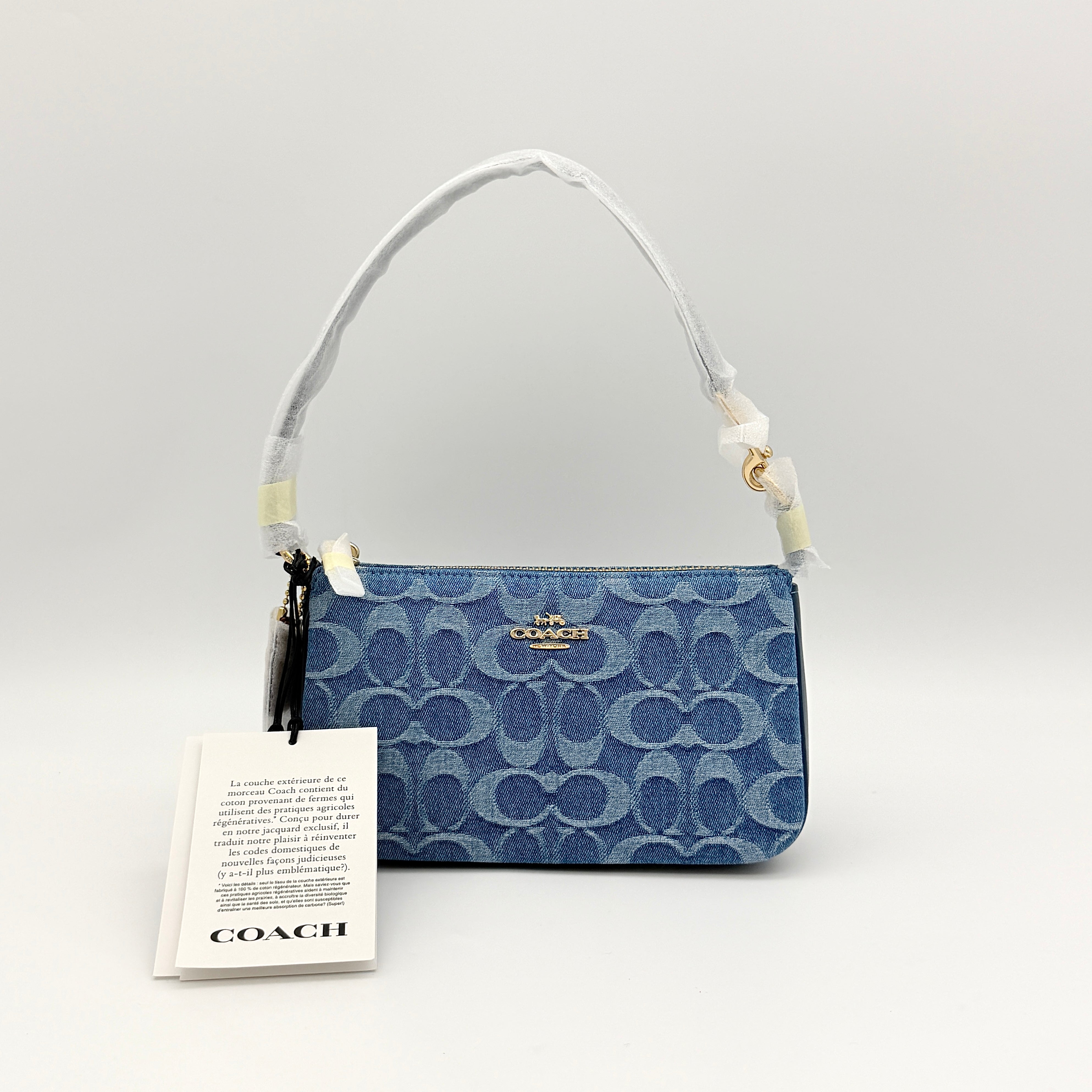 Coach Nolita 19 shoulder bag in blue denim jacquard with monogram print and gold hardware, shown with original packaging.