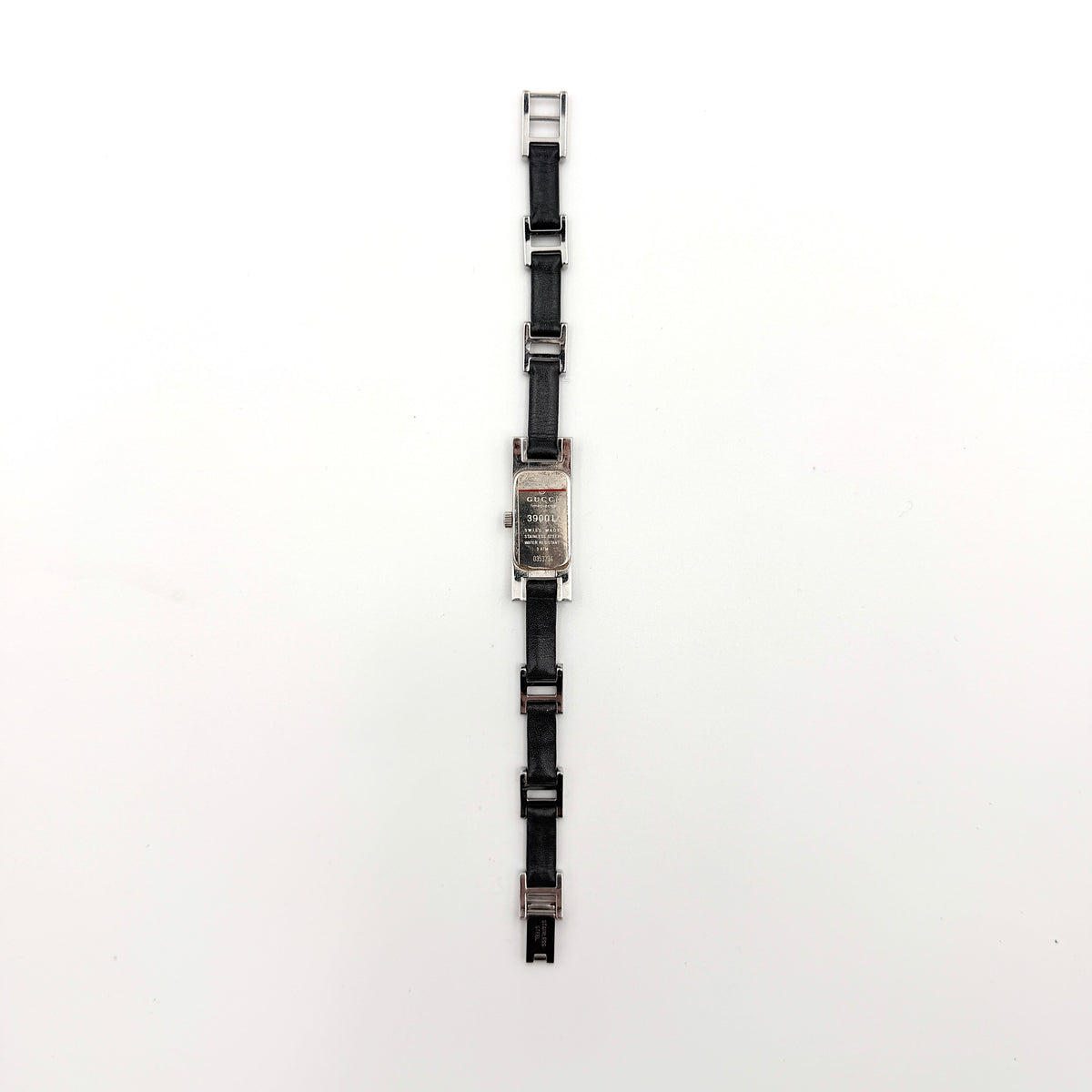 Gucci 3900L black dial watch with silver-tone rectangular case and black leather strap displayed on a stand
