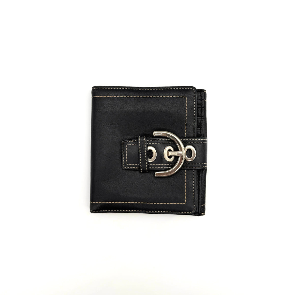 Coach black Soho Bifold Wallet with signature silver buckle and contrast stitching, shown closed against a white background.