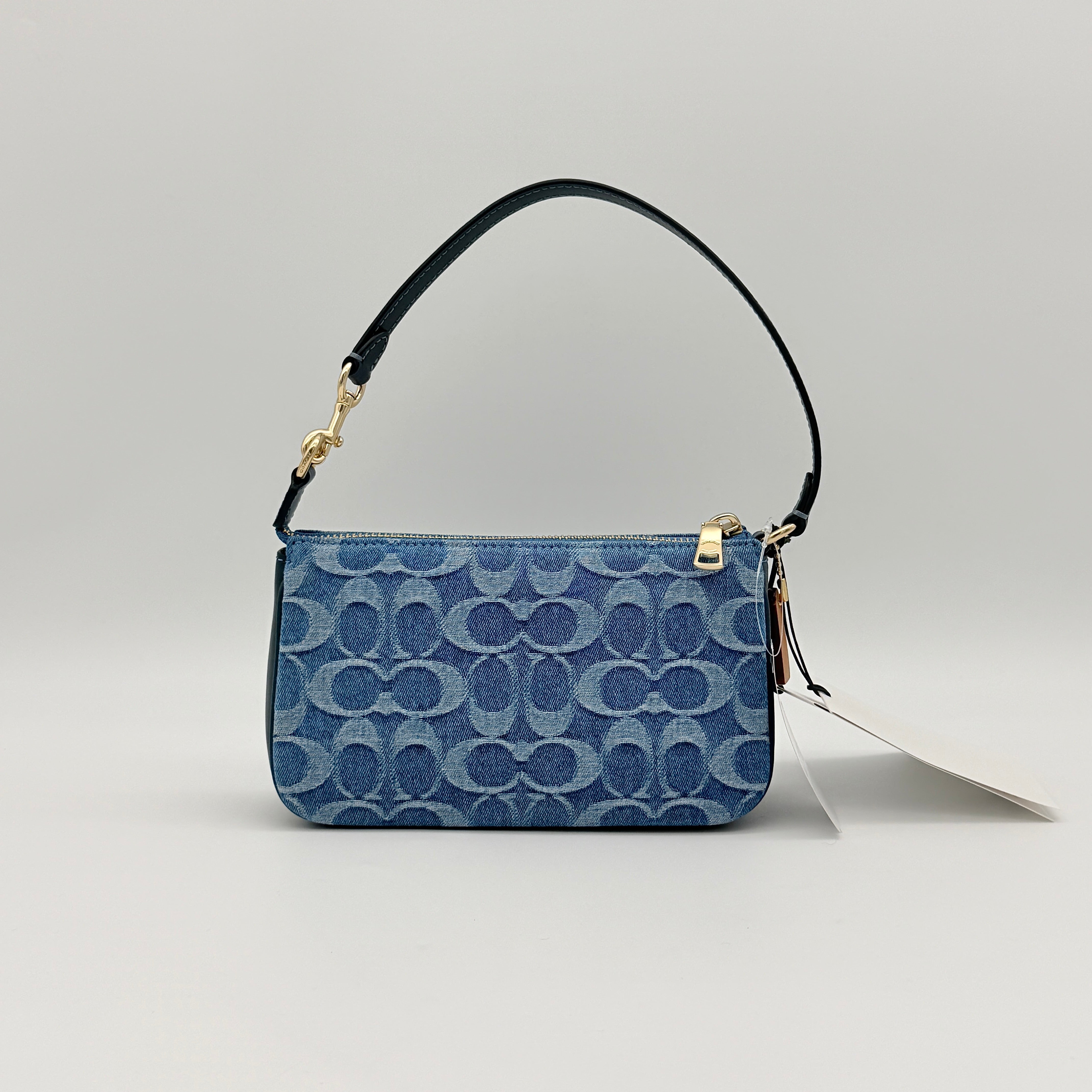 Coach Nolita 19 shoulder bag in blue denim jacquard with monogram print and gold hardware, shown with original packaging.
