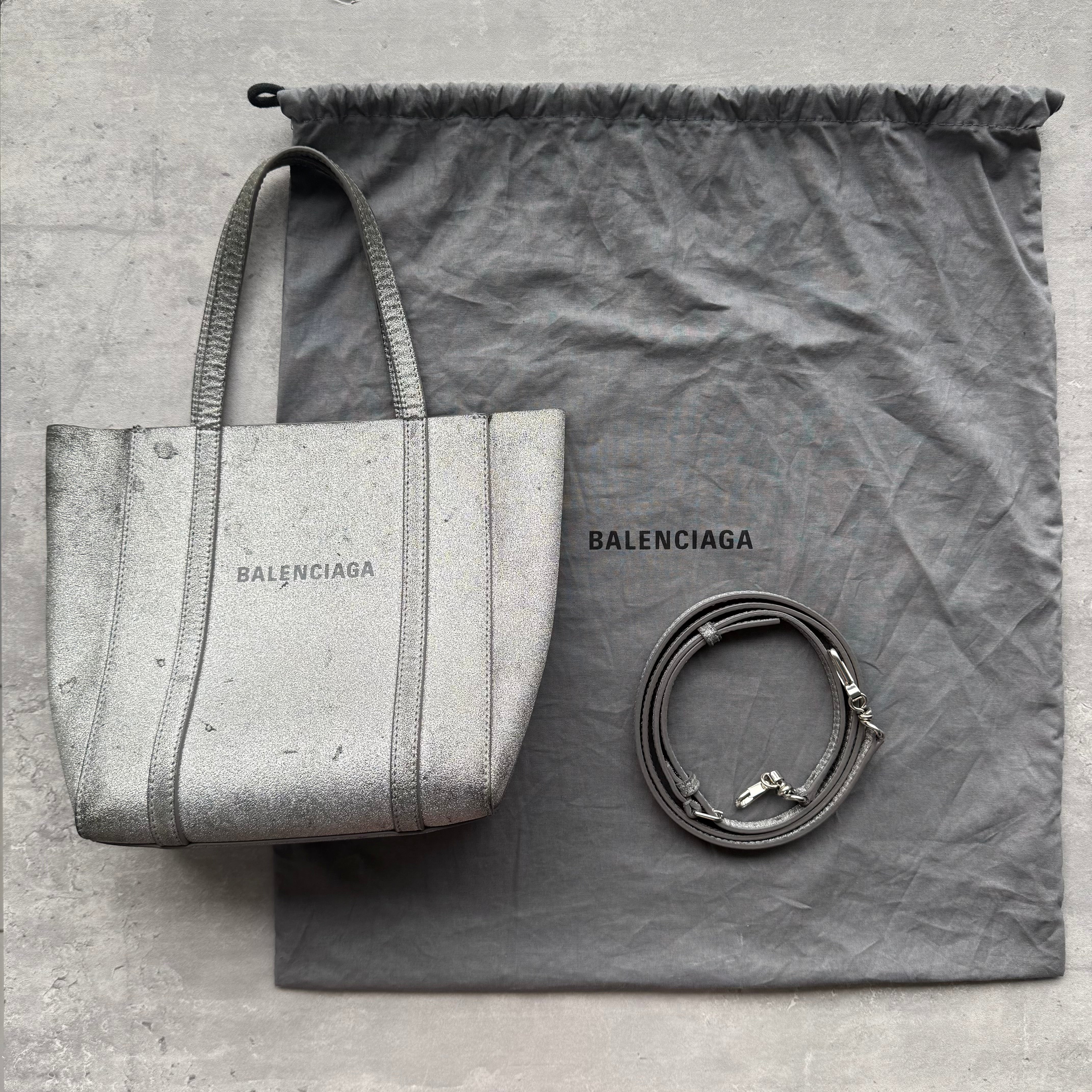 Balenciaga Glitter Everyday Tote Bag in silver with black logo print, tonal leather trim, top handles, detachable strap, and dust bag