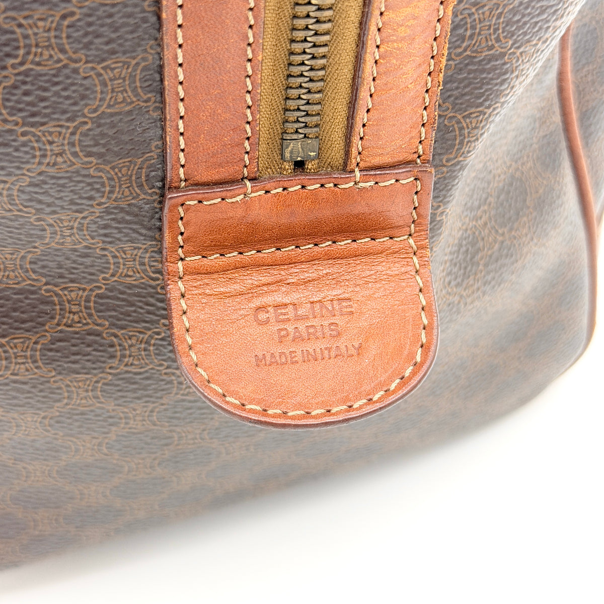 Celine Macadam Triomphe Boston Bag in brown coated canvas with tan leather and gold-tone hardware, shown against a white background.