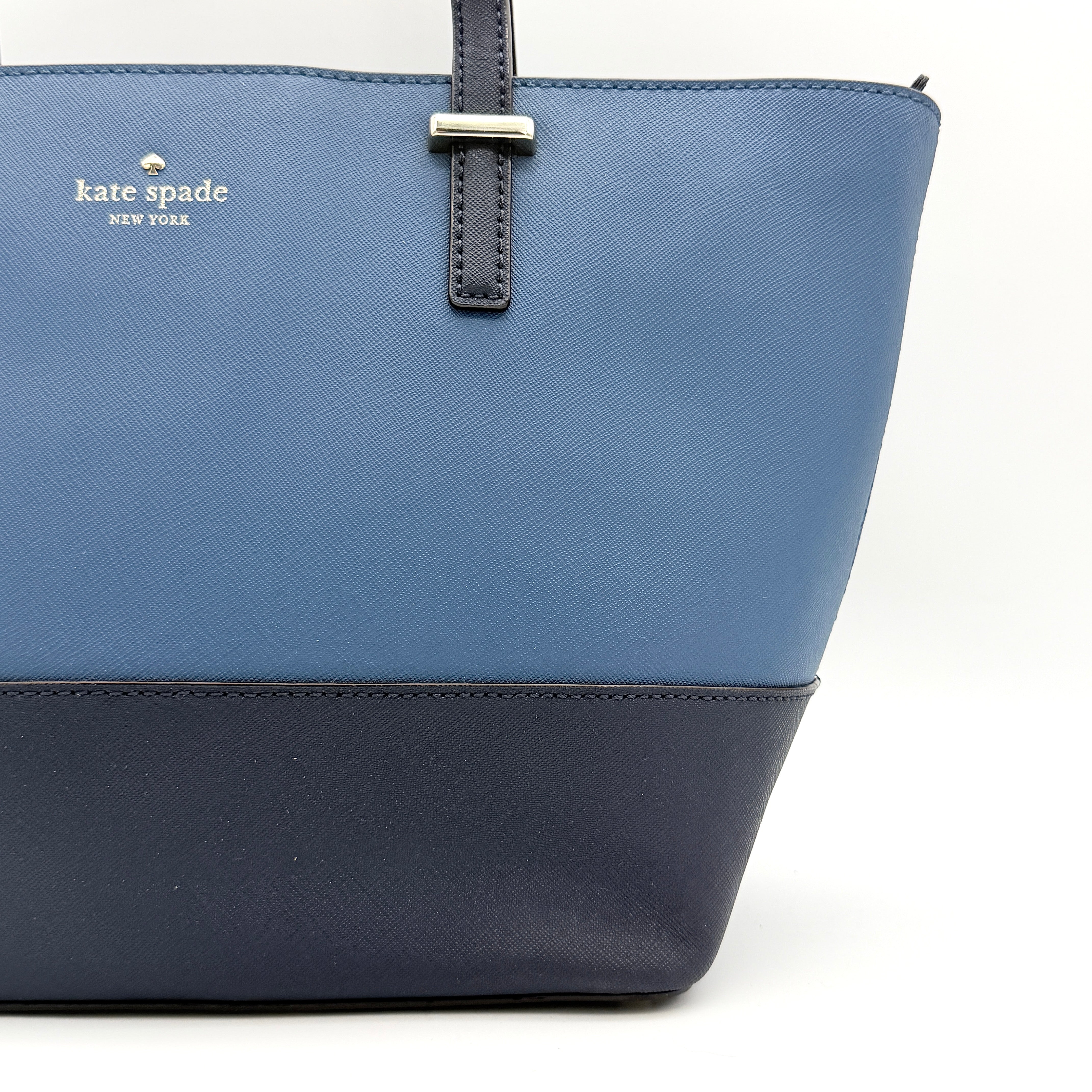 Kate Spade New York leather tote in two-tone blue with gold-tone hardware and structured handles.