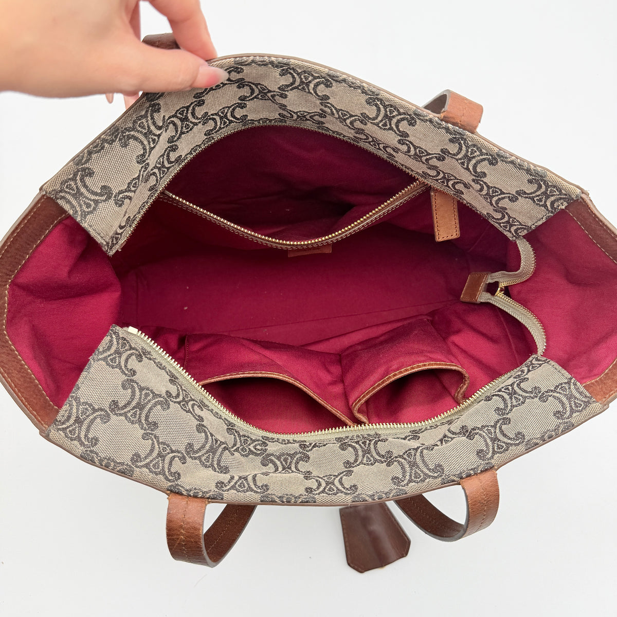 Celine Triomphe Macadam Canvas Tote Bag in beige and brown with leather trim and top handles, styled against a white background.