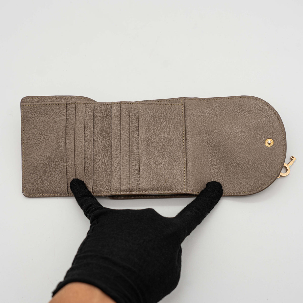 See by Chloe Hana tri-fold wallet in grey grained leather with gold-tone ring and charms, photographed closed on a white background.