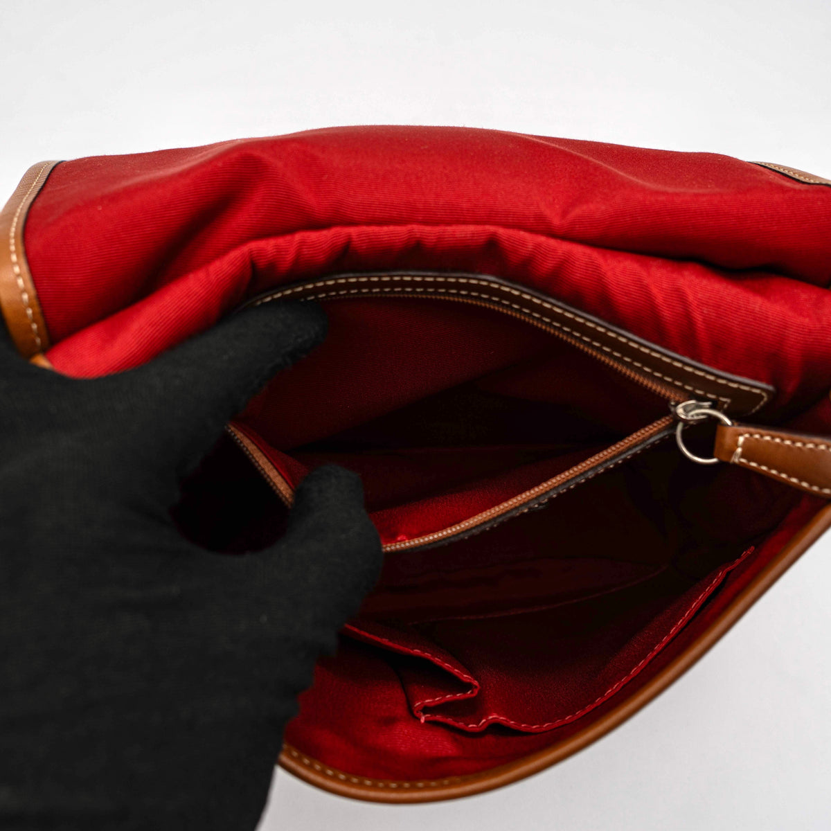 Coach signature denim hobo crossbody bag with red and blue stripe, brown leather trim, and an adjustable strap.