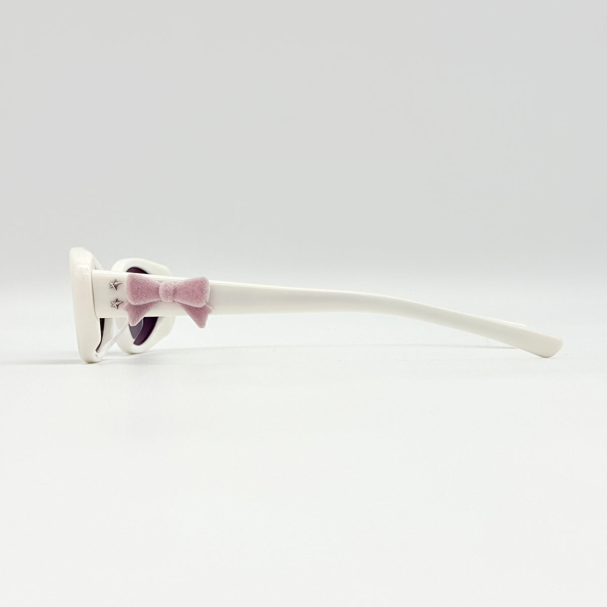 Gentle Monster x Jennie Hush W2 oval sunglasses in white with a pink bow charm, styled with the signature pink furry case.