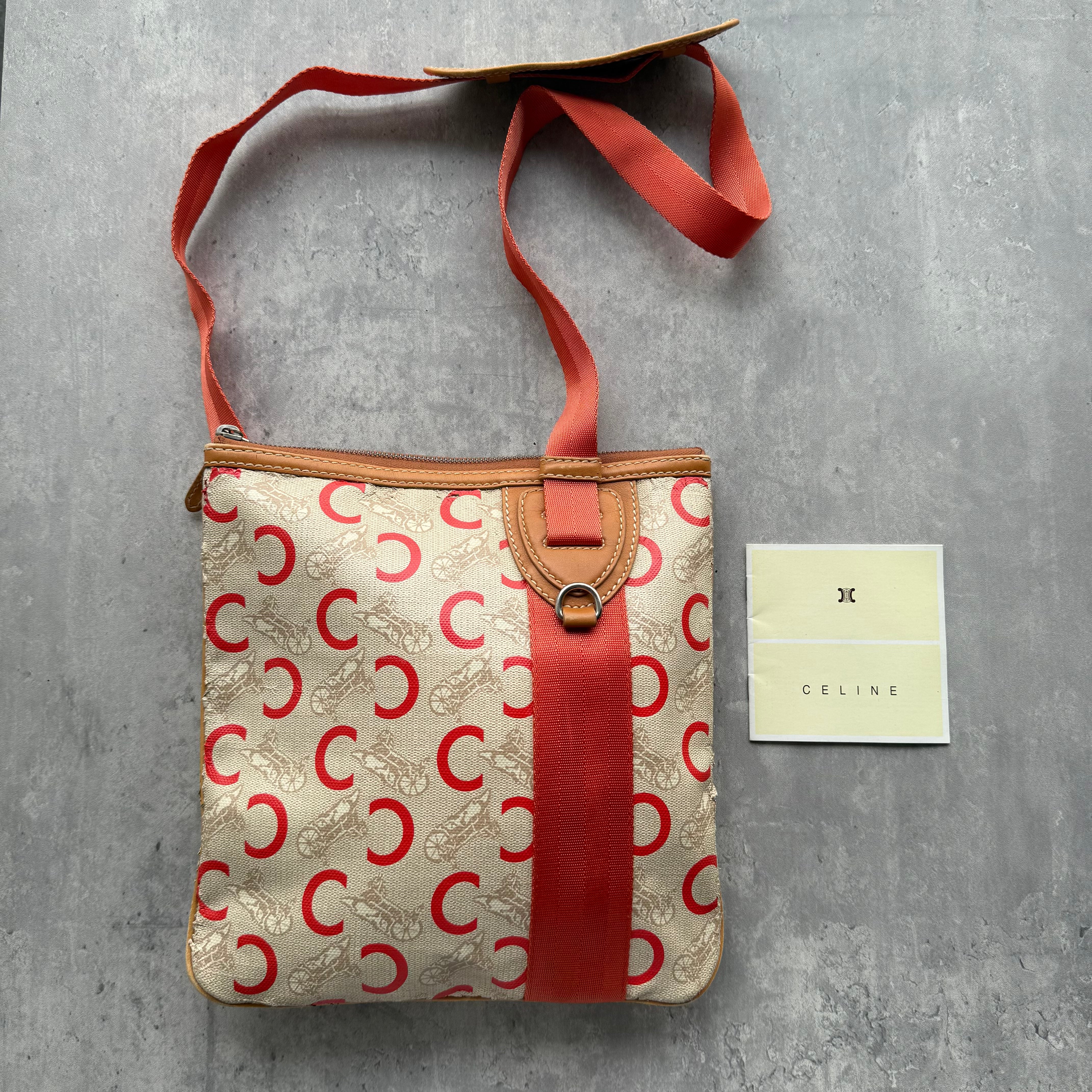 Celine Macadam Carriage Crossbody Bag in beige canvas with orange leather trim and adjustable strap.