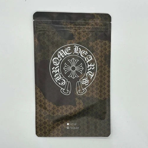 Chrome Hearts camouflage face mask with tonal plus cross pattern and black logo ear loops, includes original resealable packaging.