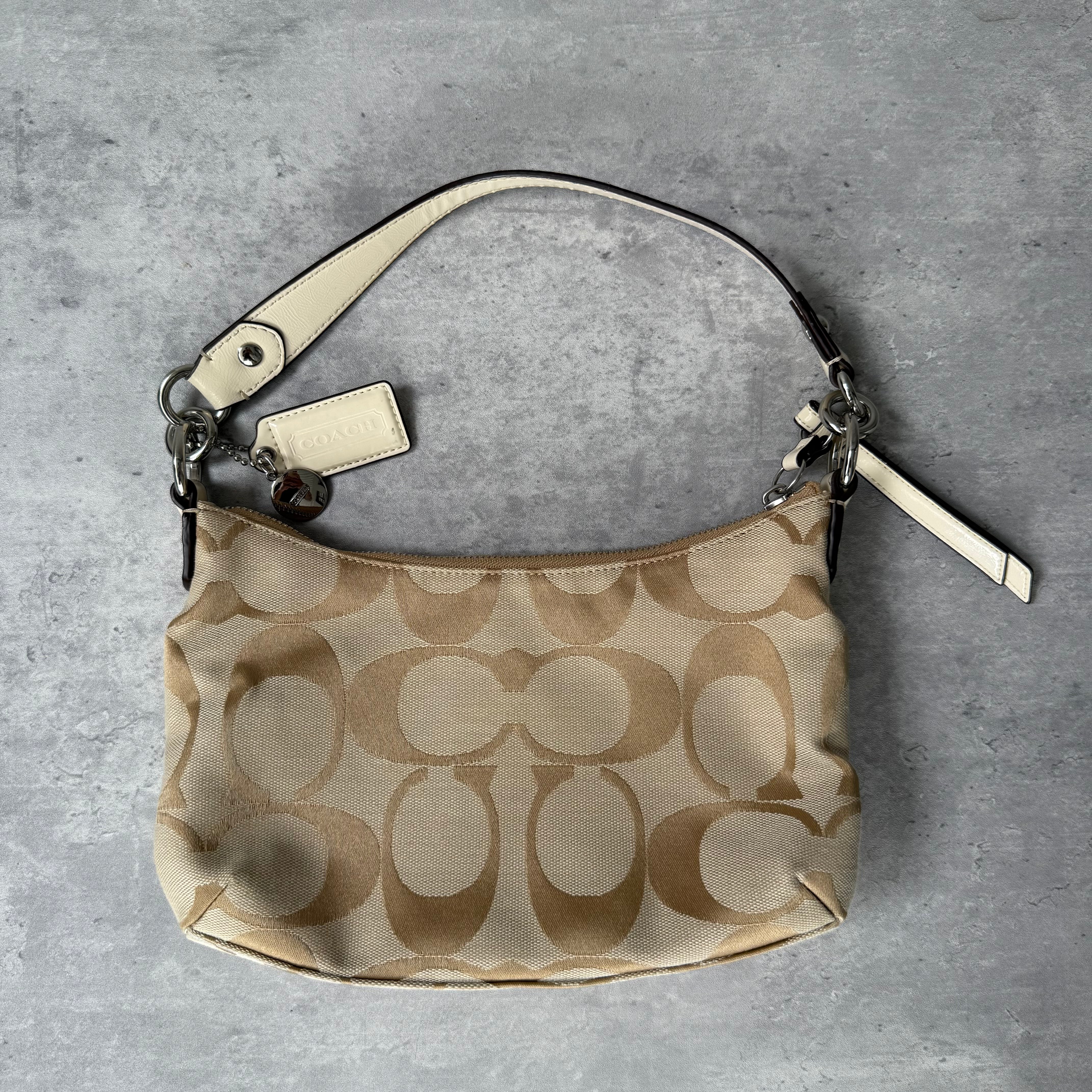 Coach 2-Way Signature Stripe Shoulder Bag in Beige and White with detachable strap, zip closure, and central white leather stripe with metal Coach emblem