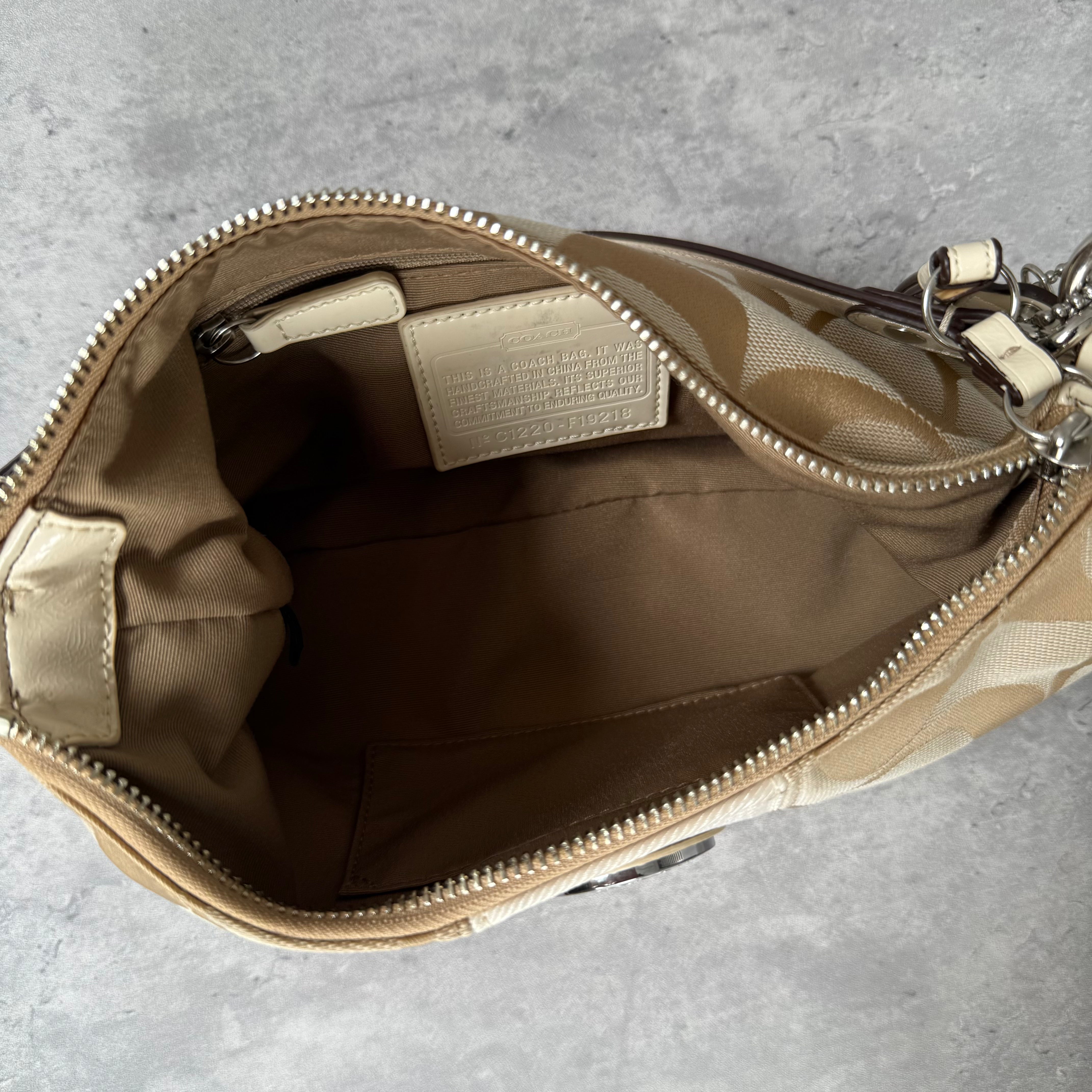 Coach 2-Way Signature Stripe Shoulder Bag in Beige and White with detachable strap, zip closure, and central white leather stripe with metal Coach emblem