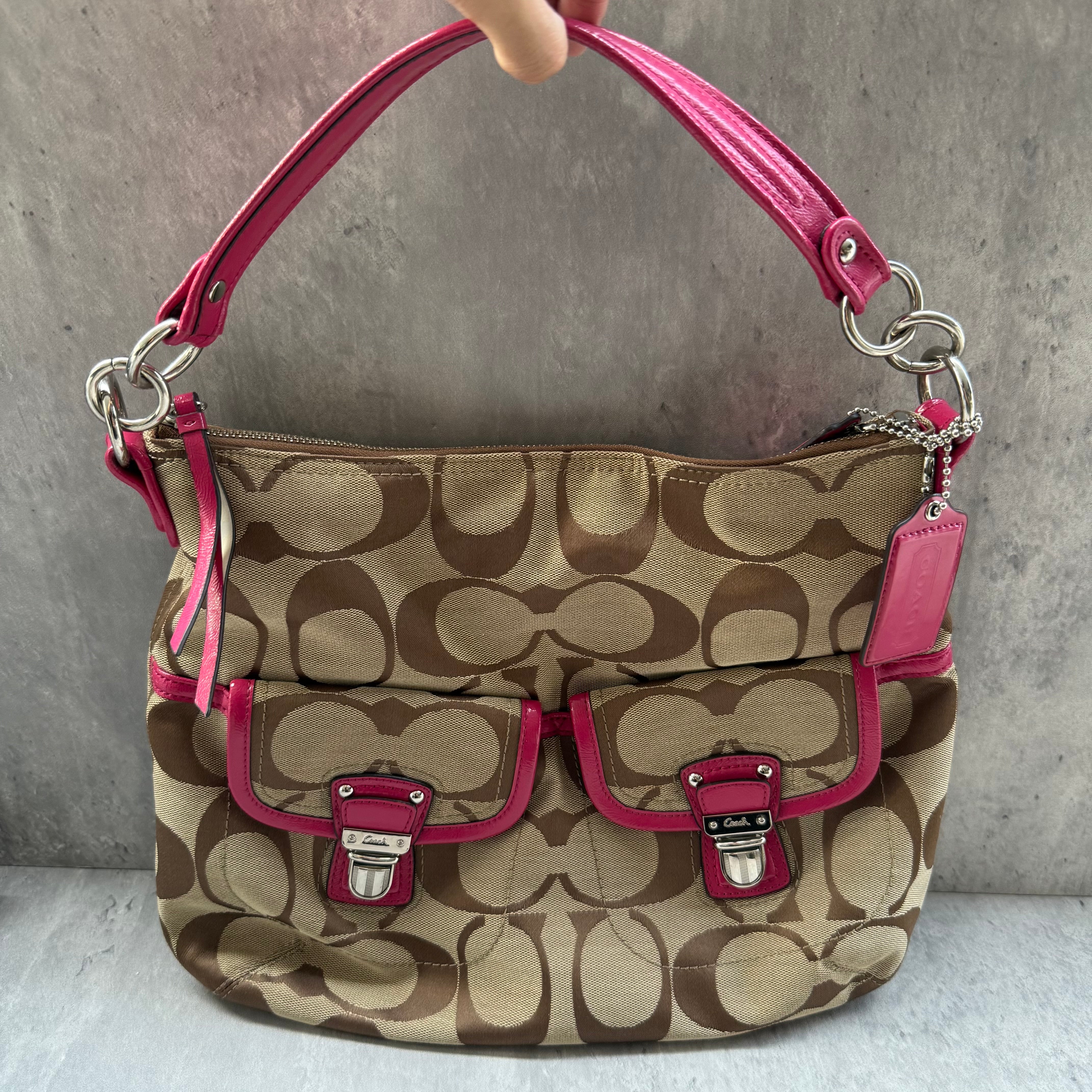 Coach 2Way Signature Pocket Hobo Daisy Bag in beige canvas with pink leather trim, dual front pockets, and detachable strap.