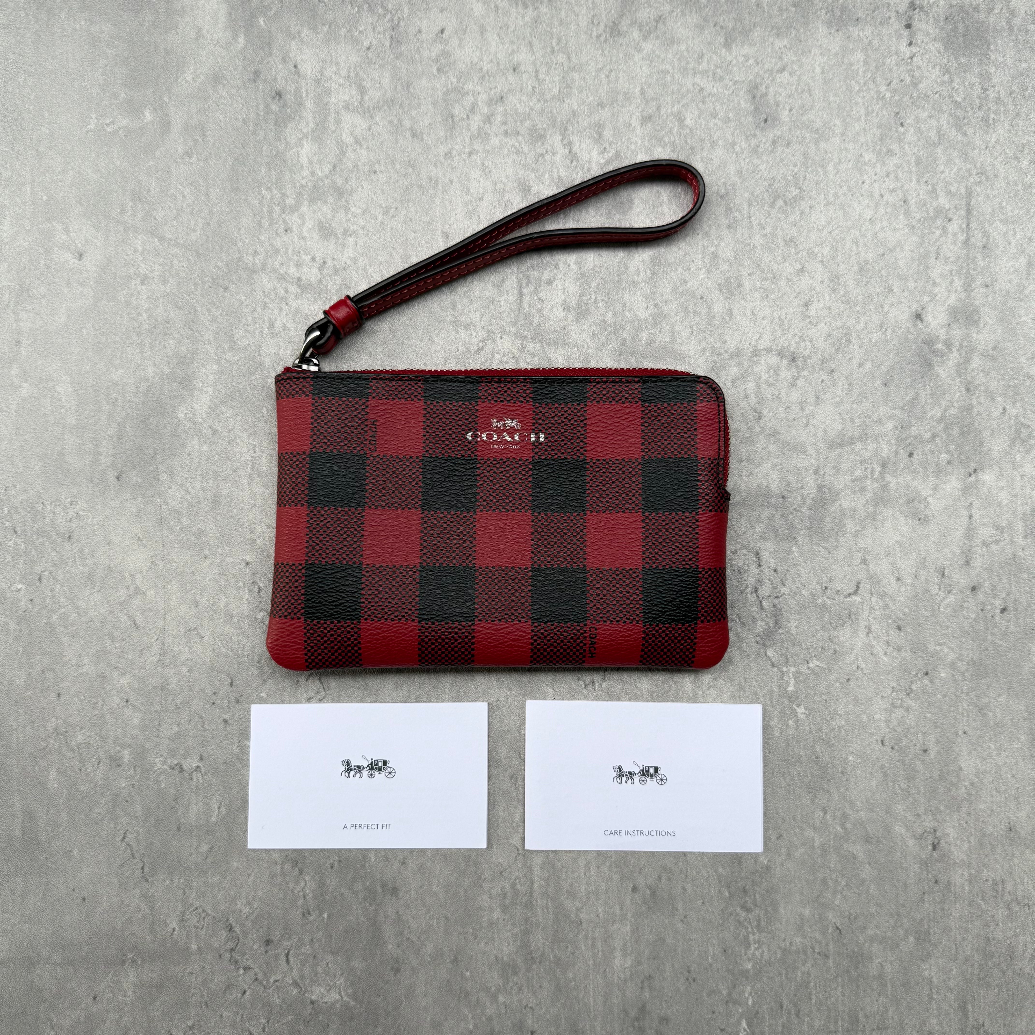 Coach Buffalo Plaid Print Zip Wristlet in red and black coated canvas with silver-tone hardware and wrist strap.