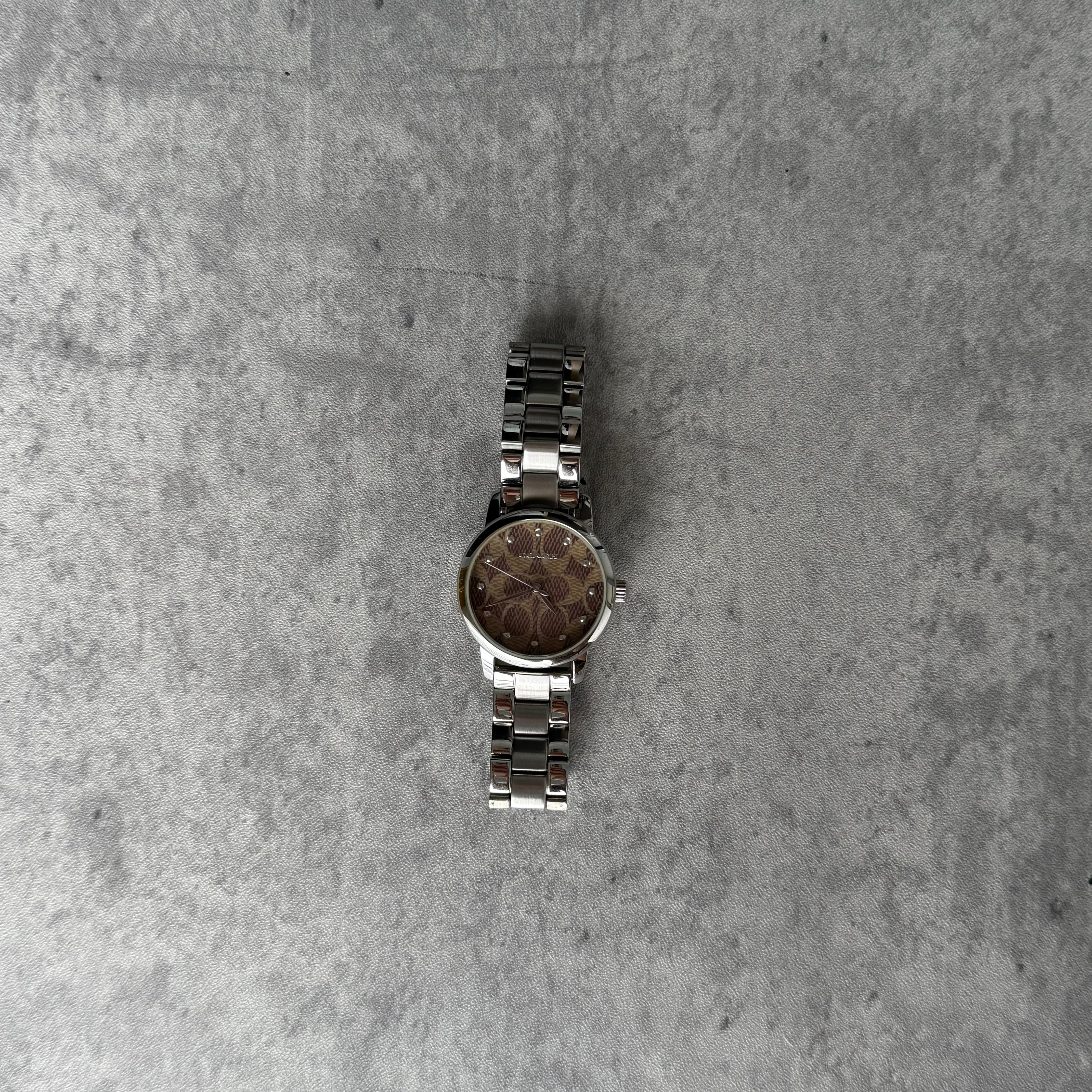 Coach Classic Logo Brown Dial Silver Watch with stainless steel bracelet and signature pattern dial.