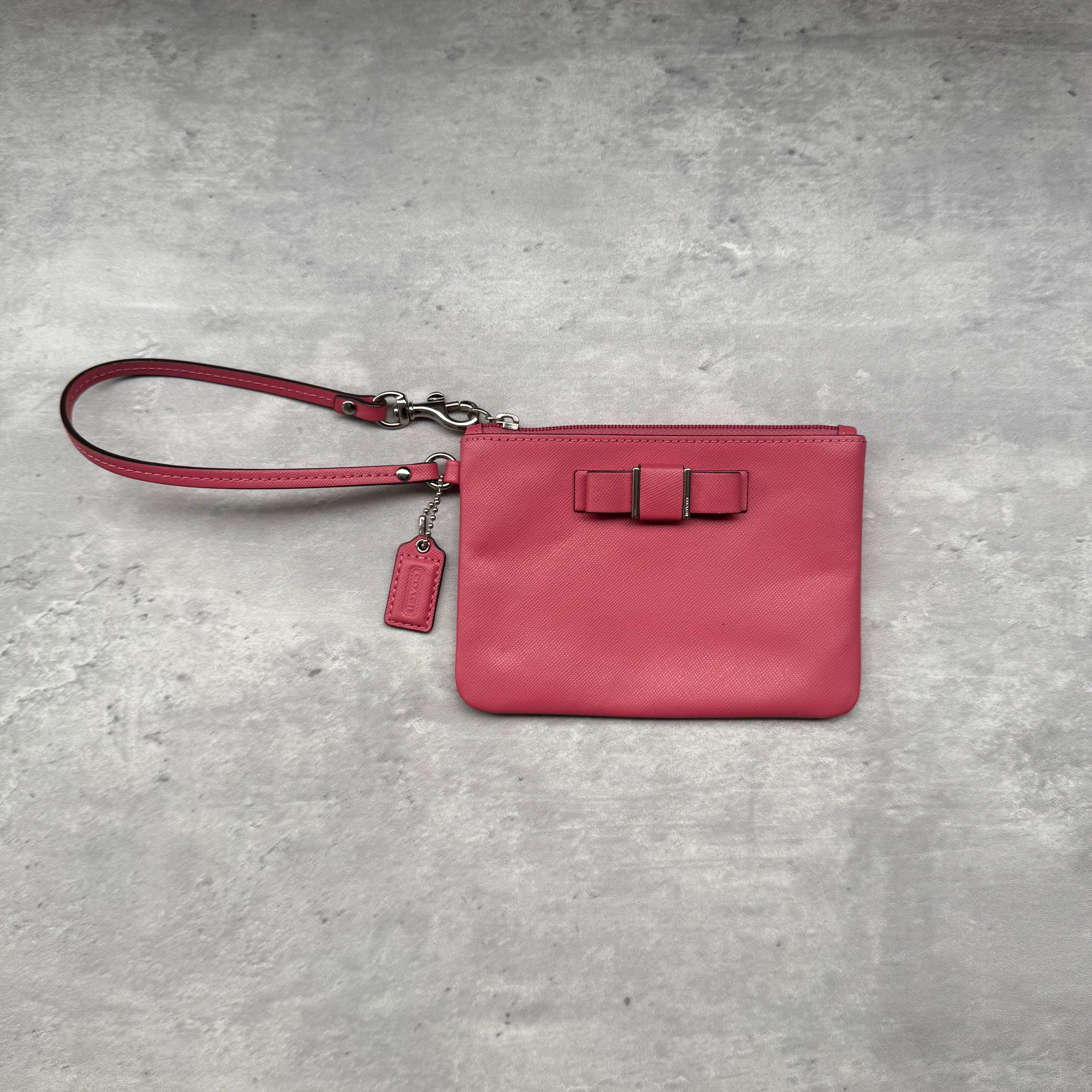 Coach Darcy Bow Small Wristlet in pink leather with bow accent, silver-tone hardware, and zip closure.