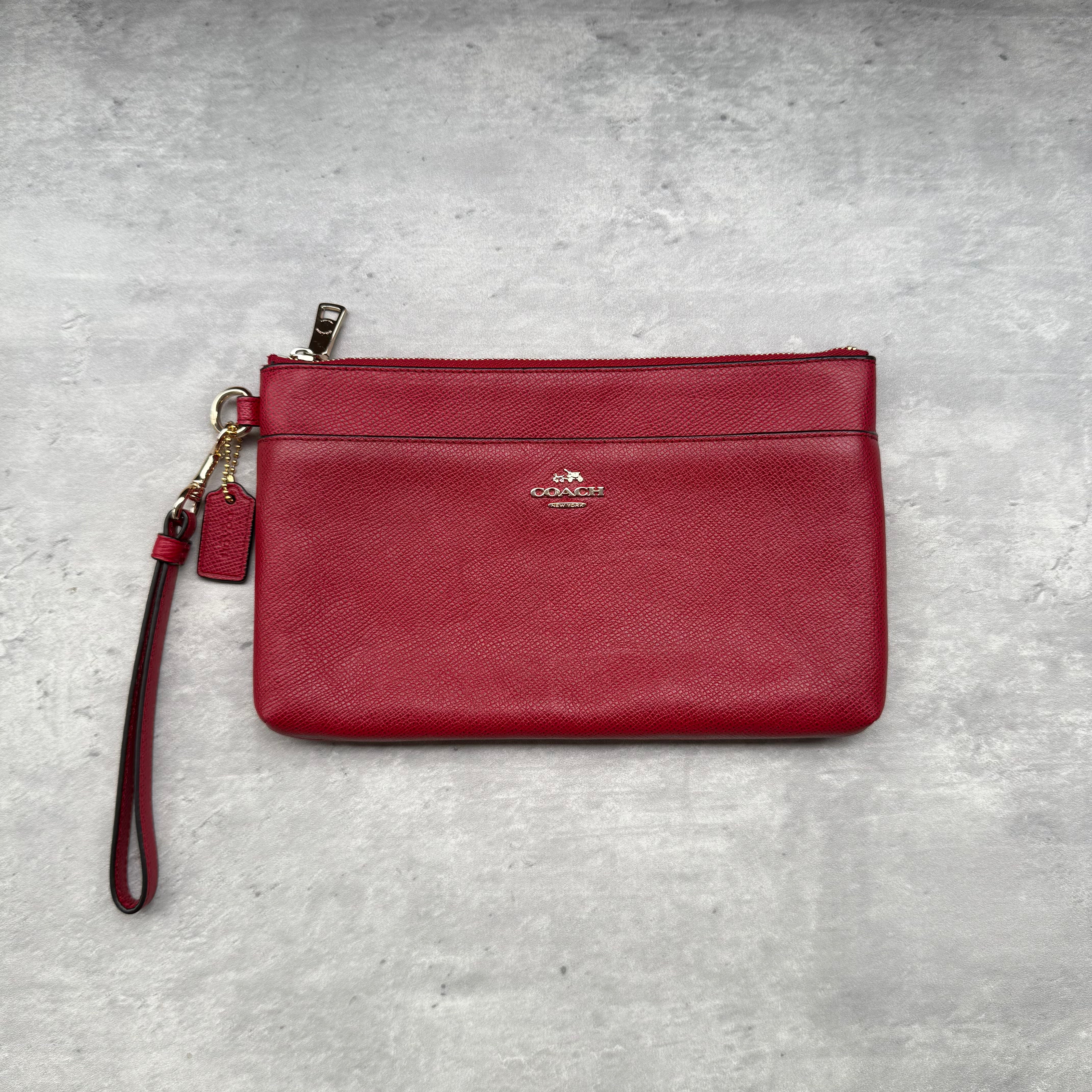 Coach Double Pocket Wristlet in red, crafted from smooth leather with dual zip compartments and silver-tone hardware.