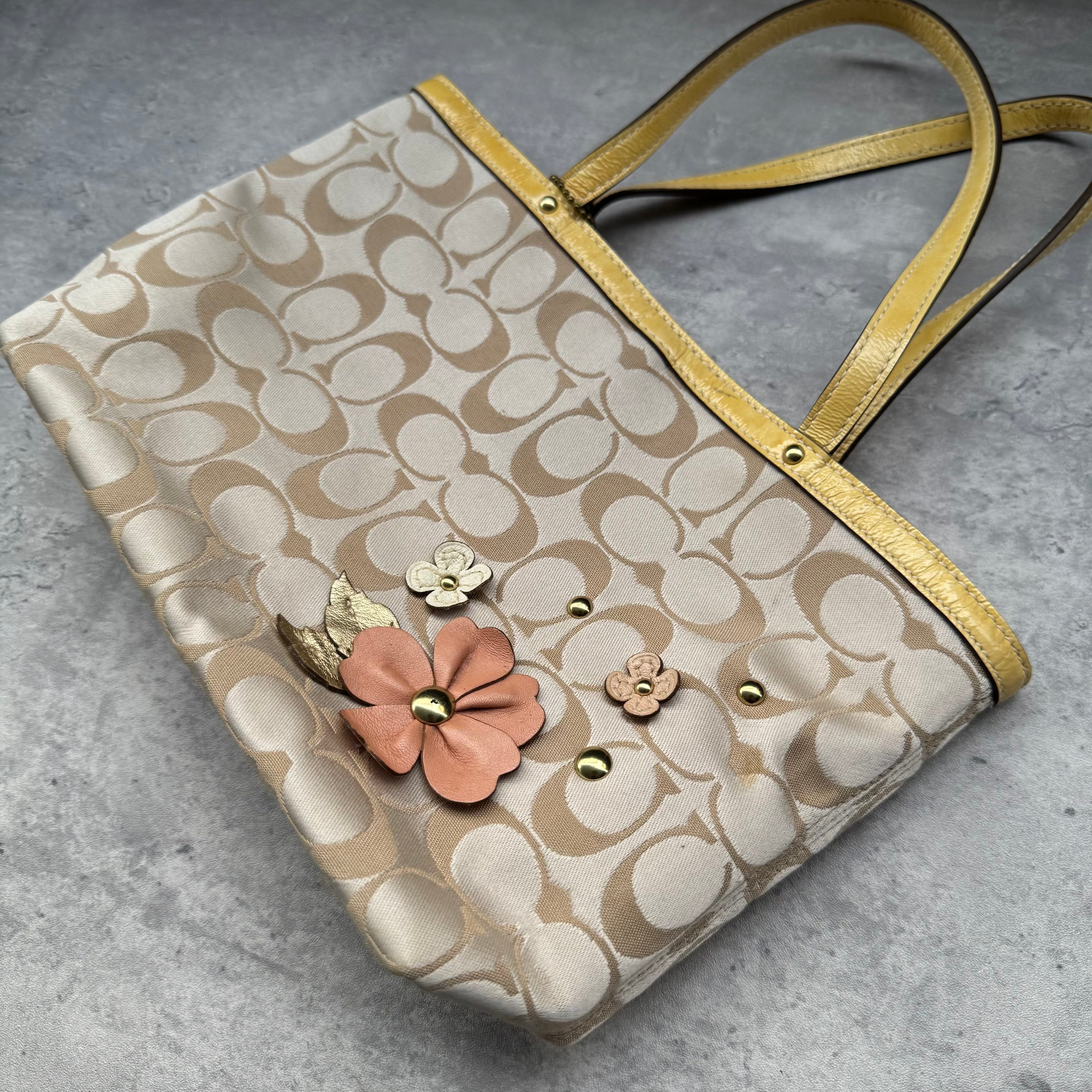 Coach Floral Applique Tote Bag in beige signature canvas with yellow leather trim and pastel leather flower details.