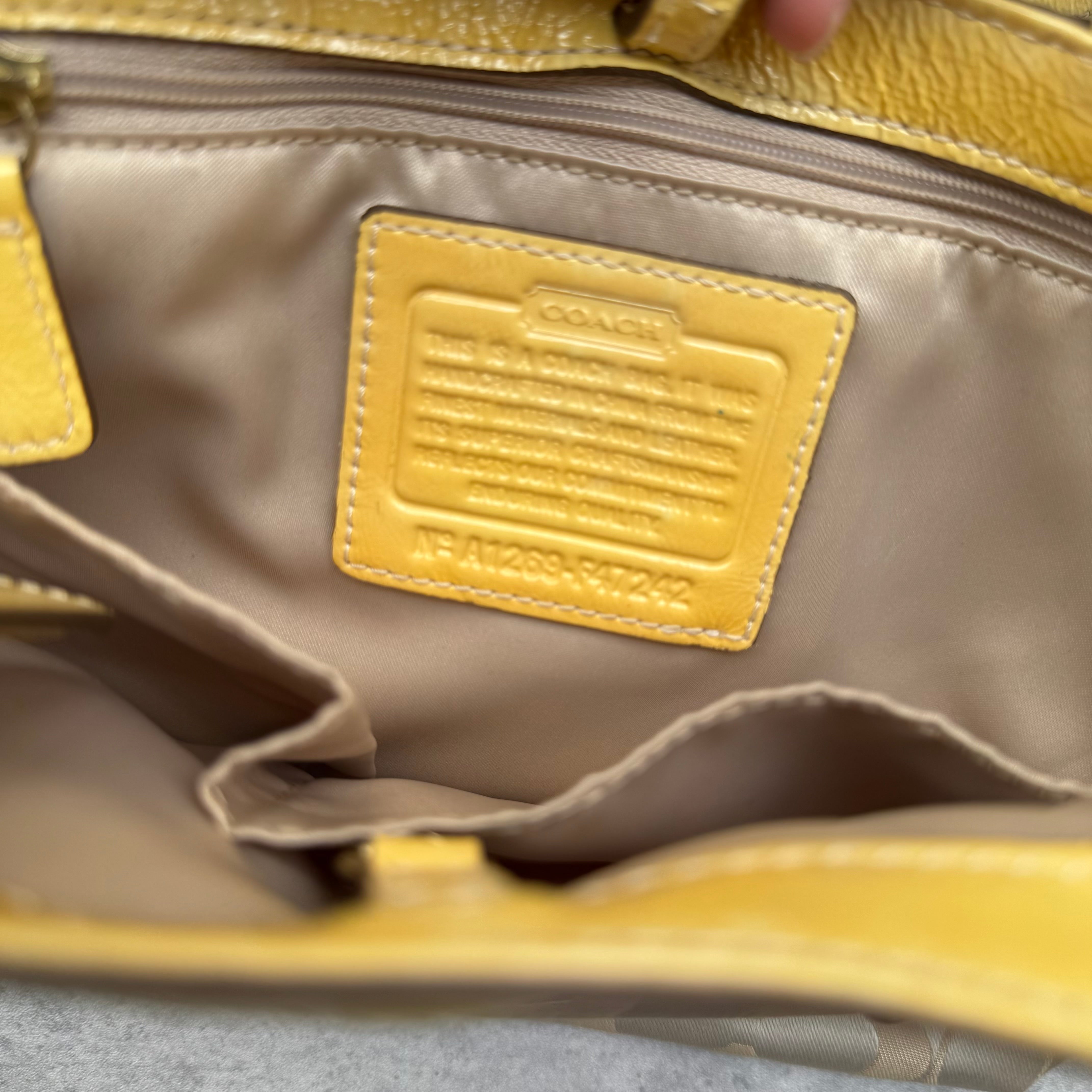 Coach Floral Applique Tote Bag in beige signature canvas with yellow leather trim and pastel leather flower details.