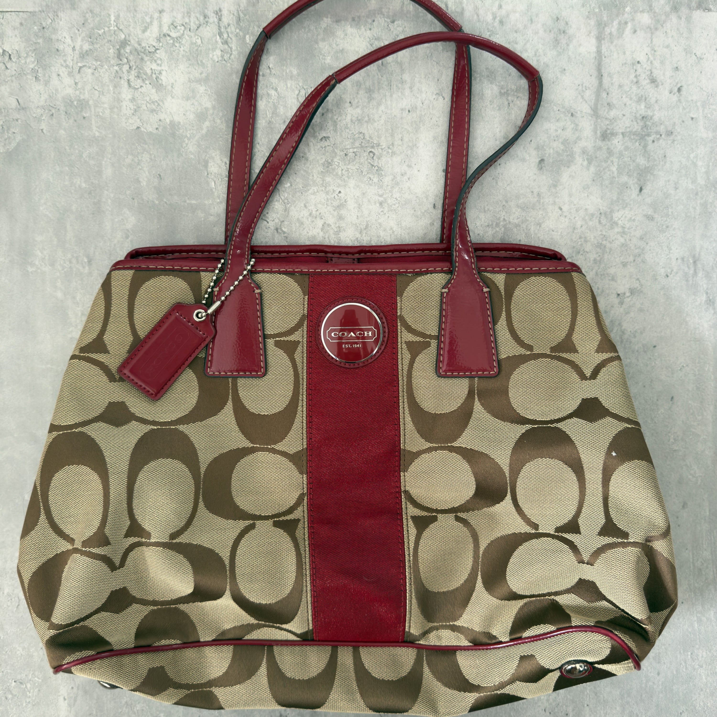 Coach Framed Kiss Lock Carryall Satchel in tan and red stripe with signature monogram canvas, silver-tone hardware, and spacious red fabric-lined interior.