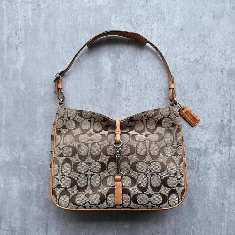 Coach Hobo Signature Handbag in beige monogram canvas with tan leather trim, silver clip closure, and orange interior lining.