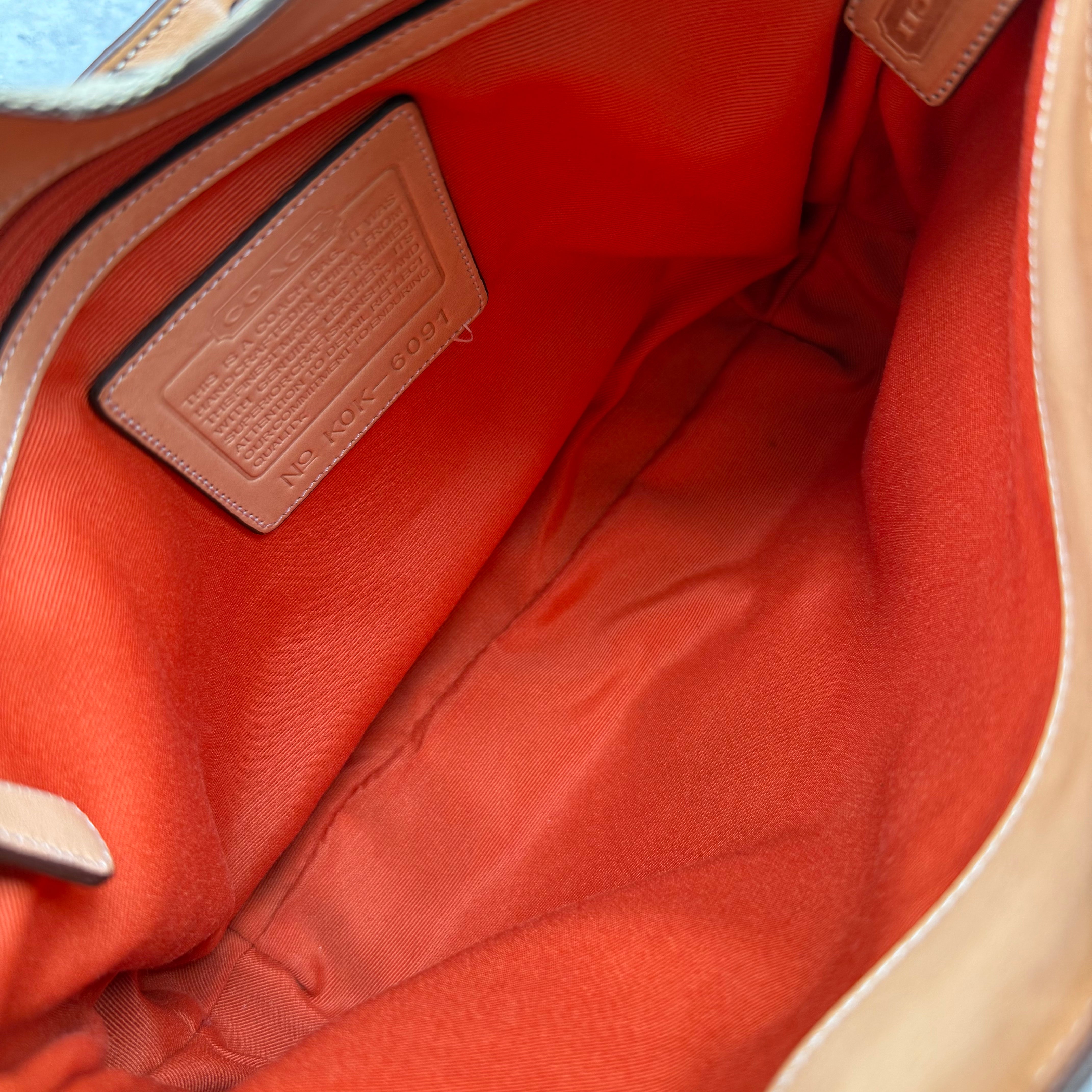 Coach Hobo Signature Clip Canvas Handbag Beige with monogram jacquard canvas, tan leather trim, front clip accent, and red-orange interior lining