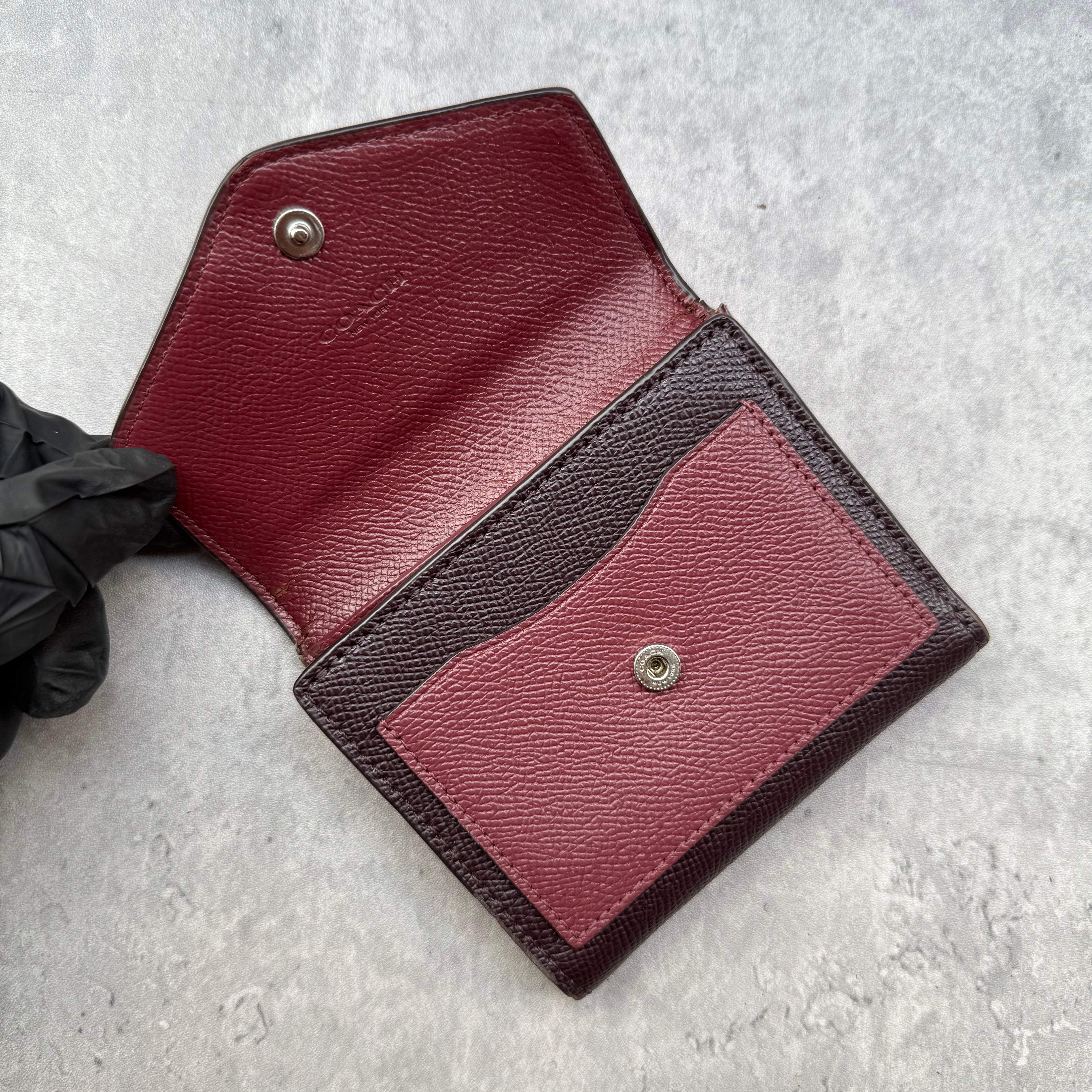 Coach Jasmine Colour-Block Small Wallet in plum, burgundy, and black pebbled leather with zip coin pocket