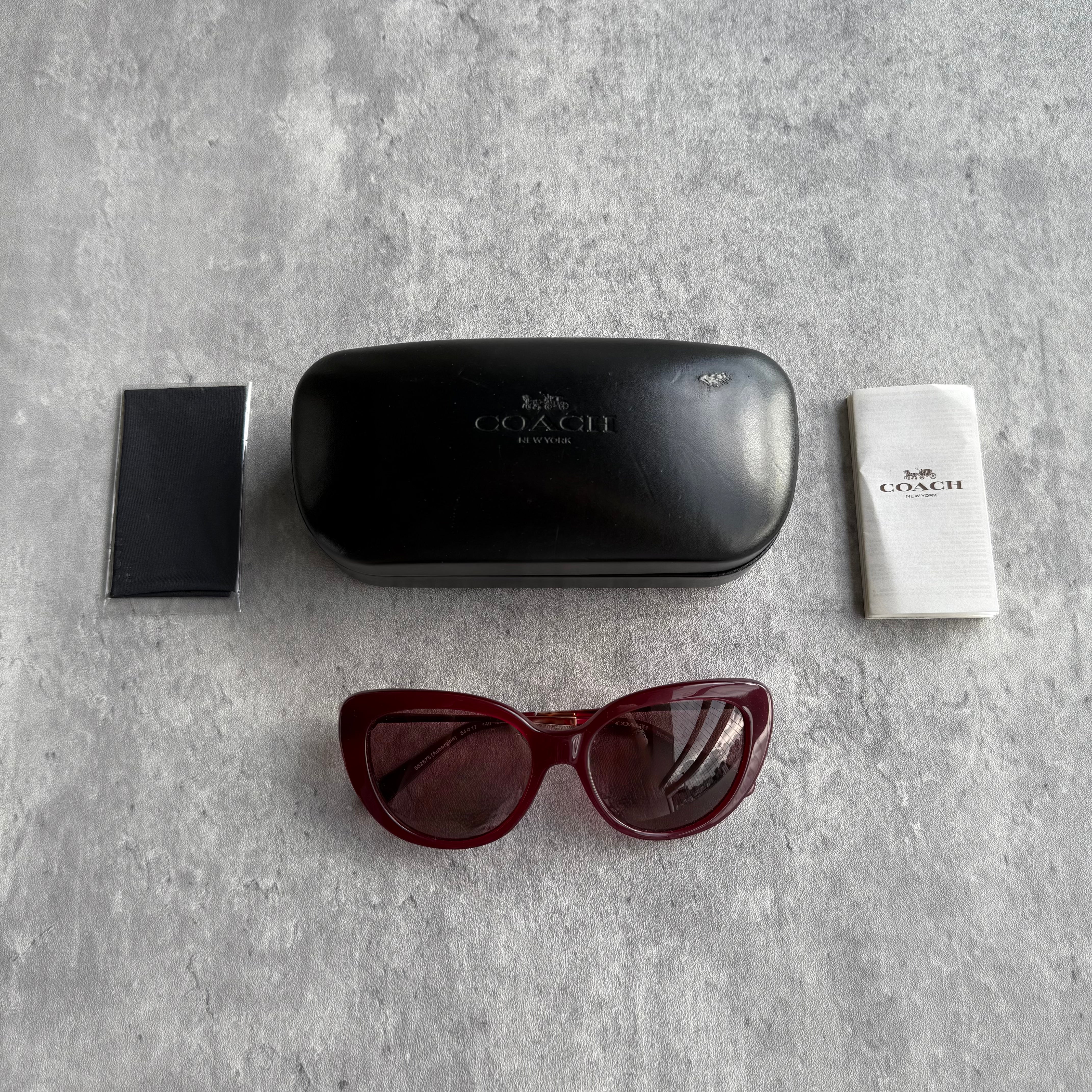 Coach Jessa Crystal Cat Eye Sunglasses in maroon crystal acetate with gradient lenses.