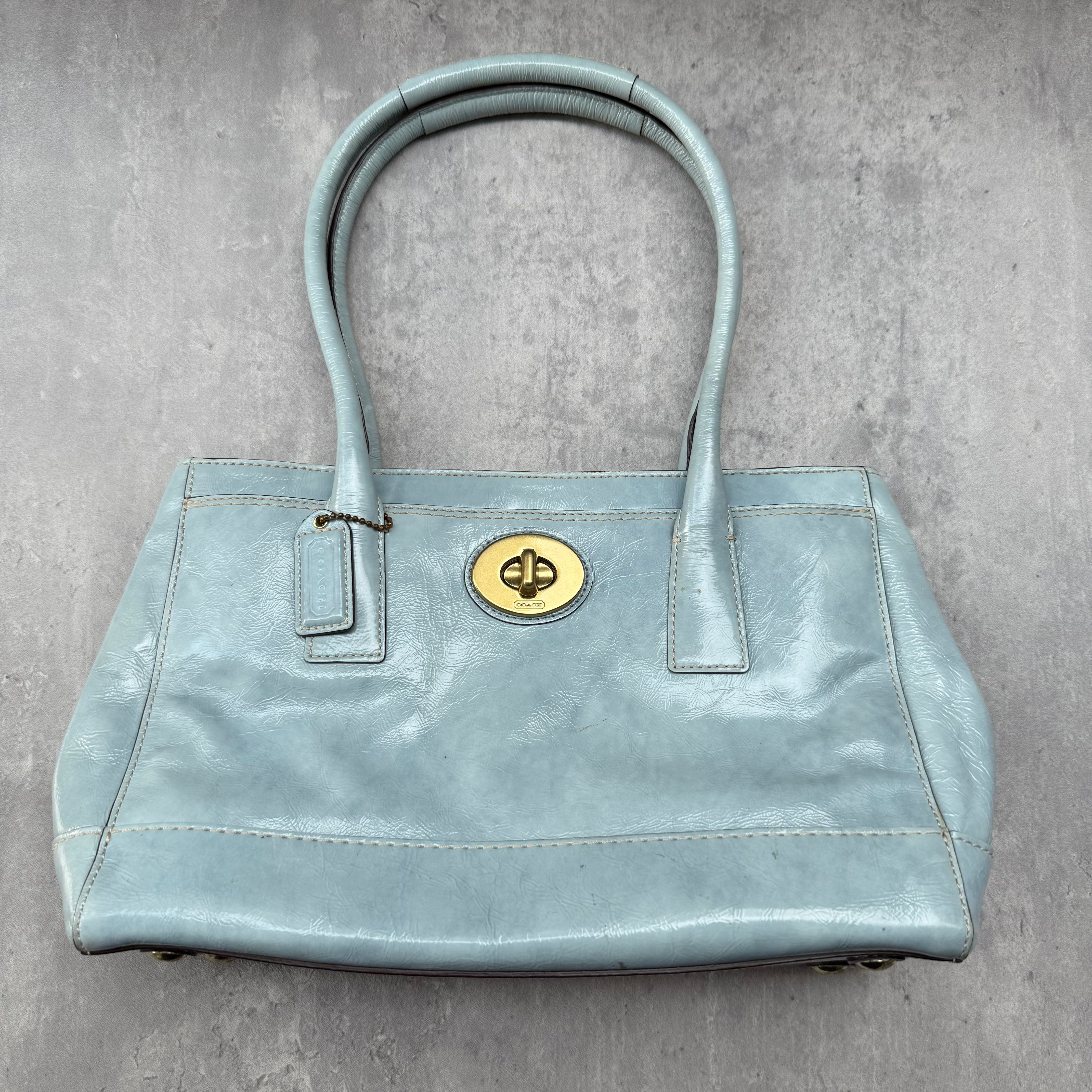 Coach Madeline Turnlock Handbag in baby blue smooth leather with gold-tone turnlock closure and beige interior.