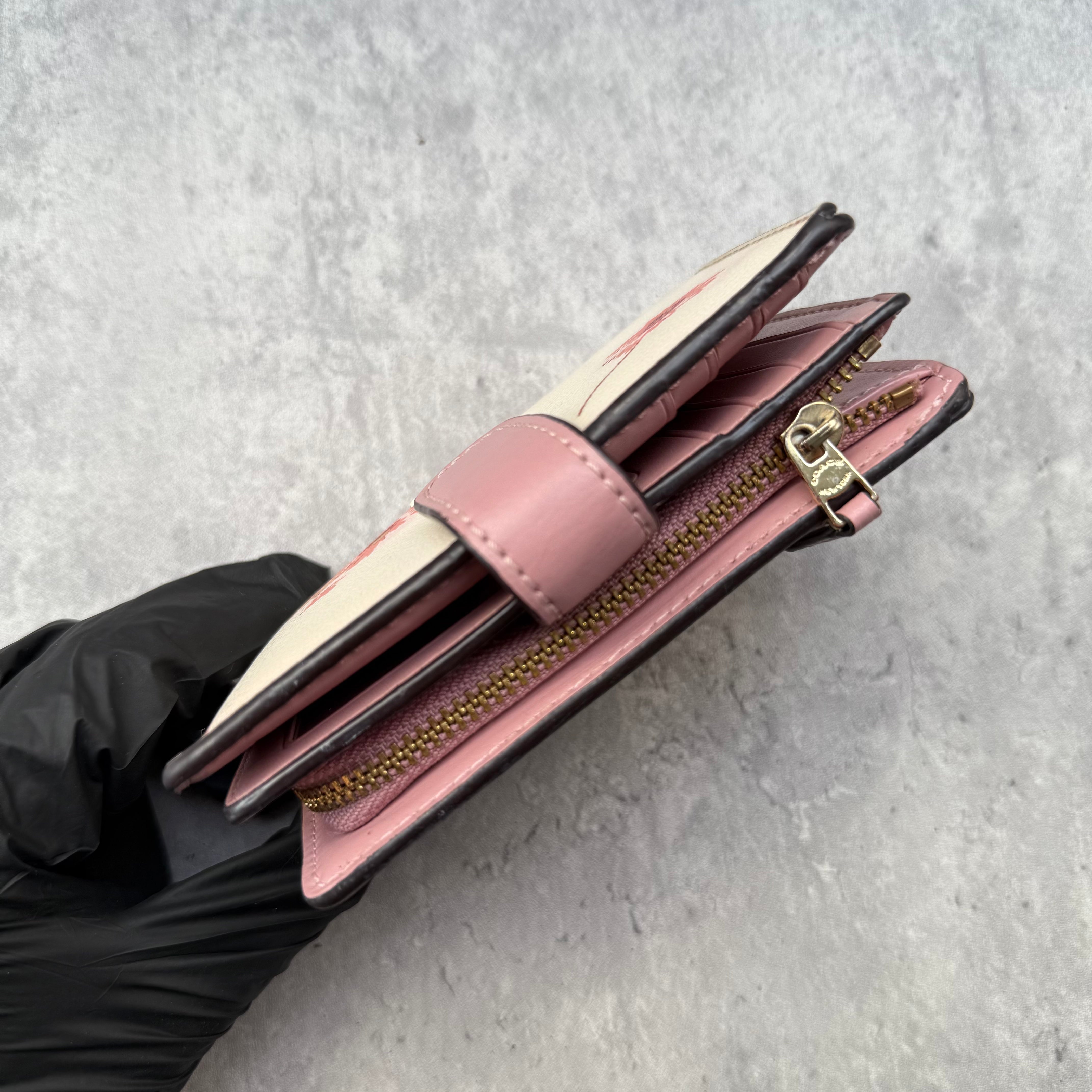 Coach Medium Corner Zip Wallet with multi floral print in ivory and pink, crafted from pebbled leather and featuring a snap tab closure and zip coin pocket.