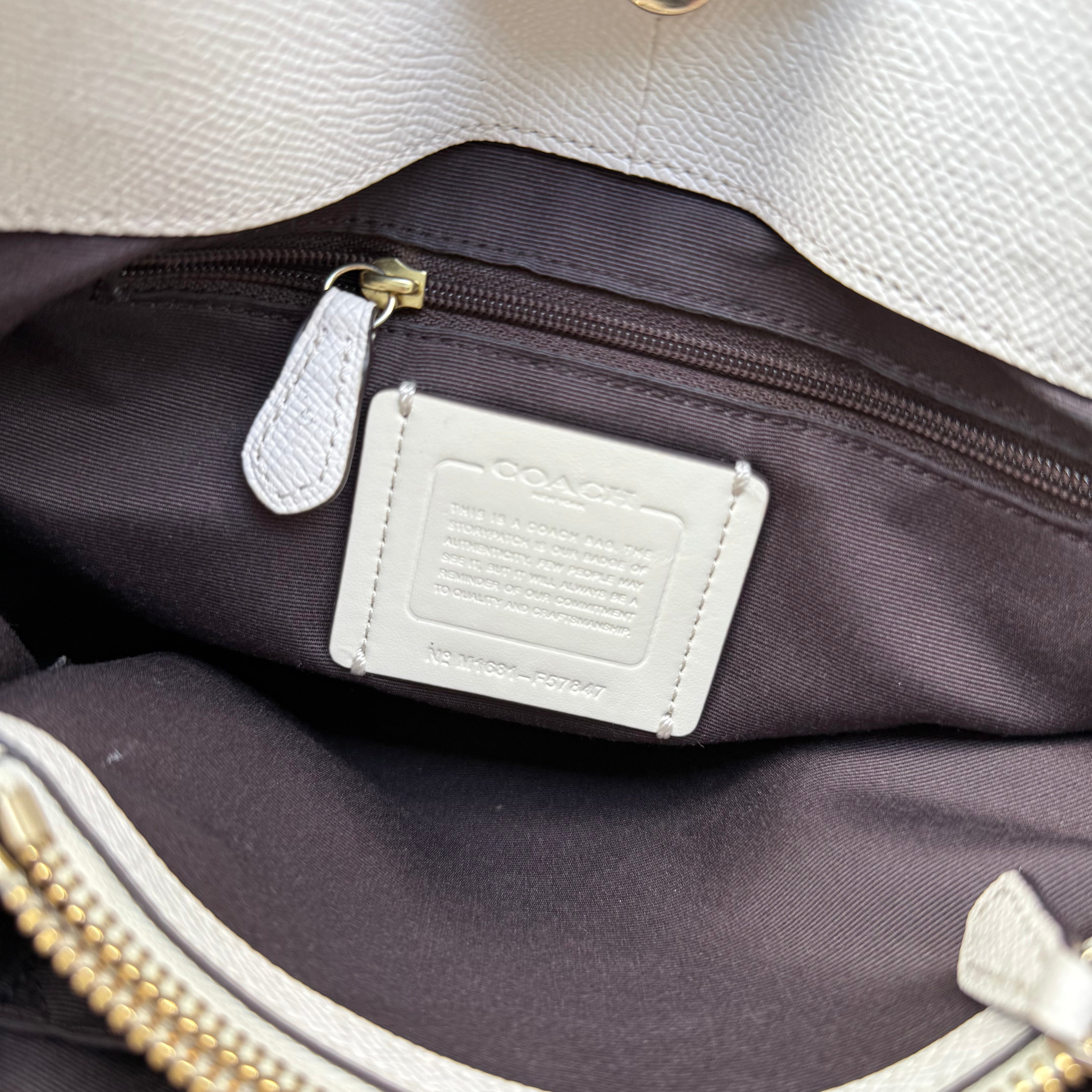  Coach Minetta Handbag in white pebbled leather with structured silhouette, top handles, and gold-tone logo