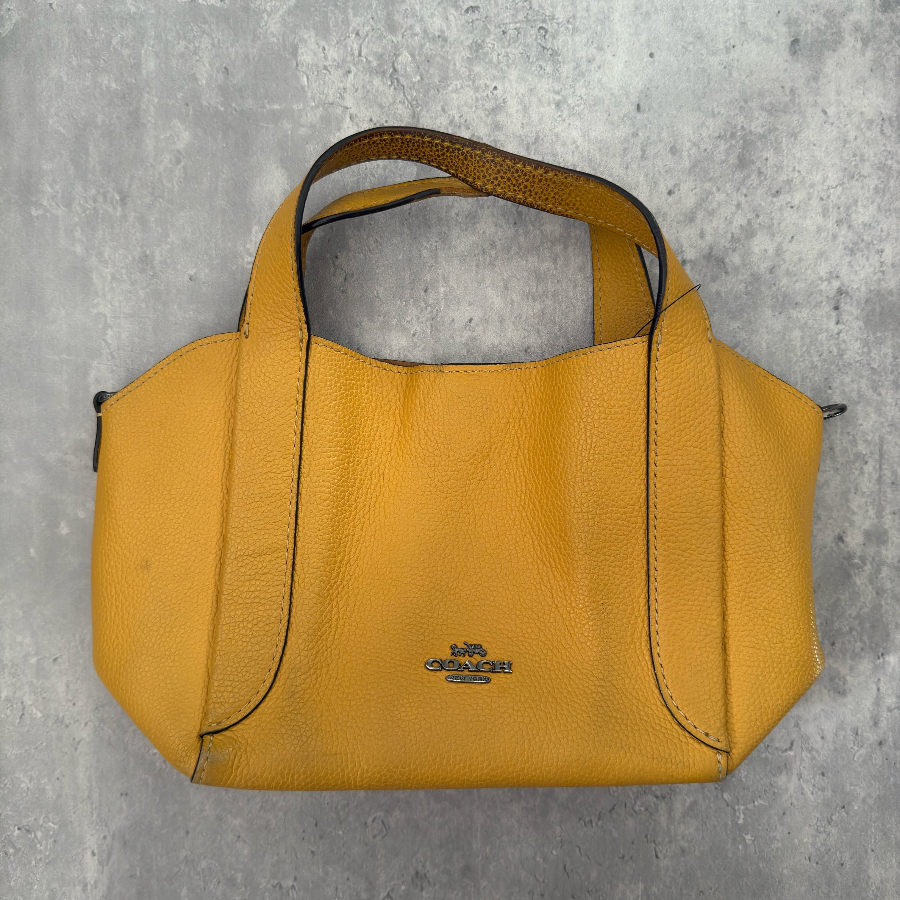 Coach Mini Yellow Leather Bag with pebbled leather texture, dual top handles, and a spacious open interior.