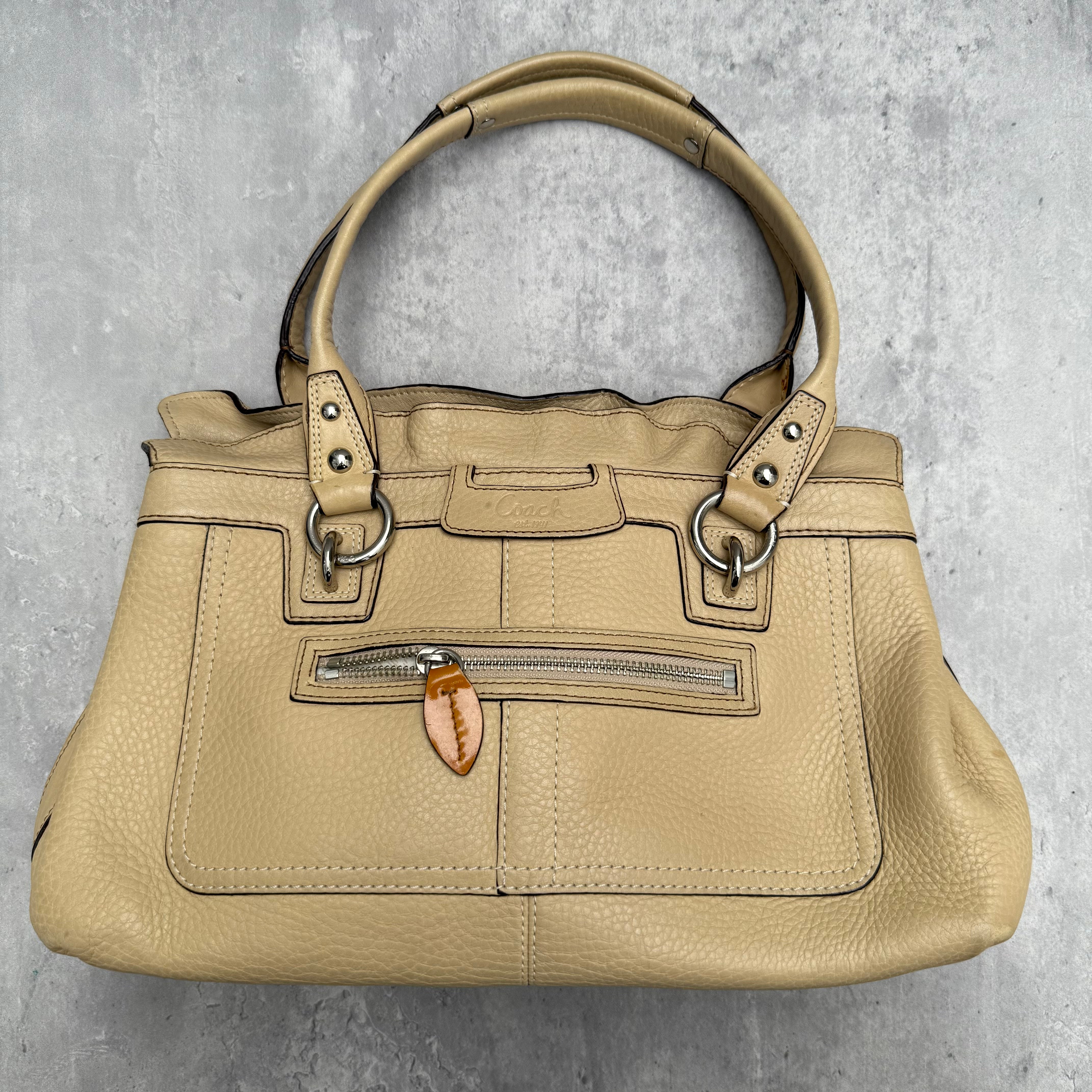 Coach Penelope Pebble Leather Handbag in cream pebble leather with silver-tone hardware and plaid interior lining.