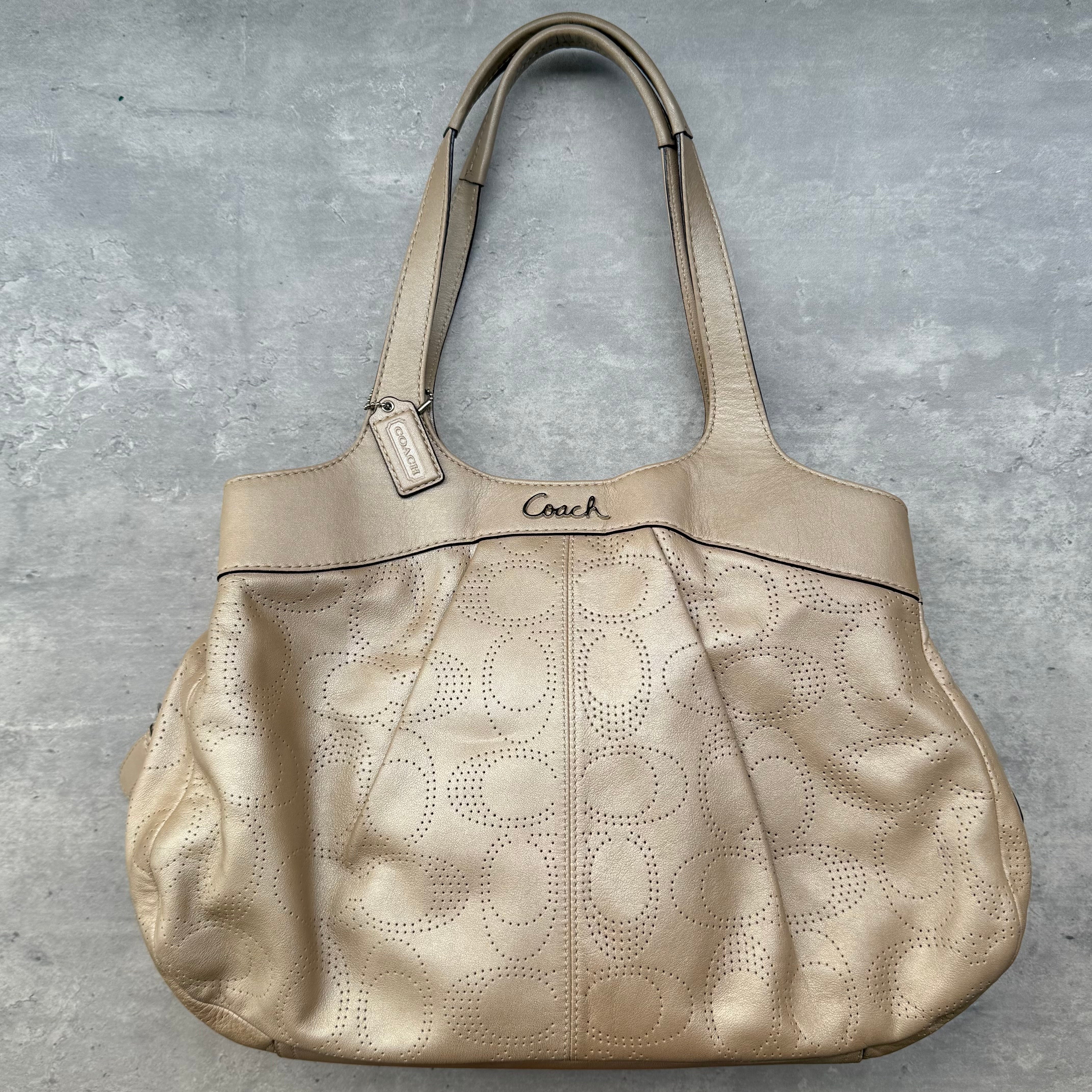 Coach Perforated Hobo Handbag in light brown leather with signature perforated pattern, dual shoulder straps, and pink satin interior