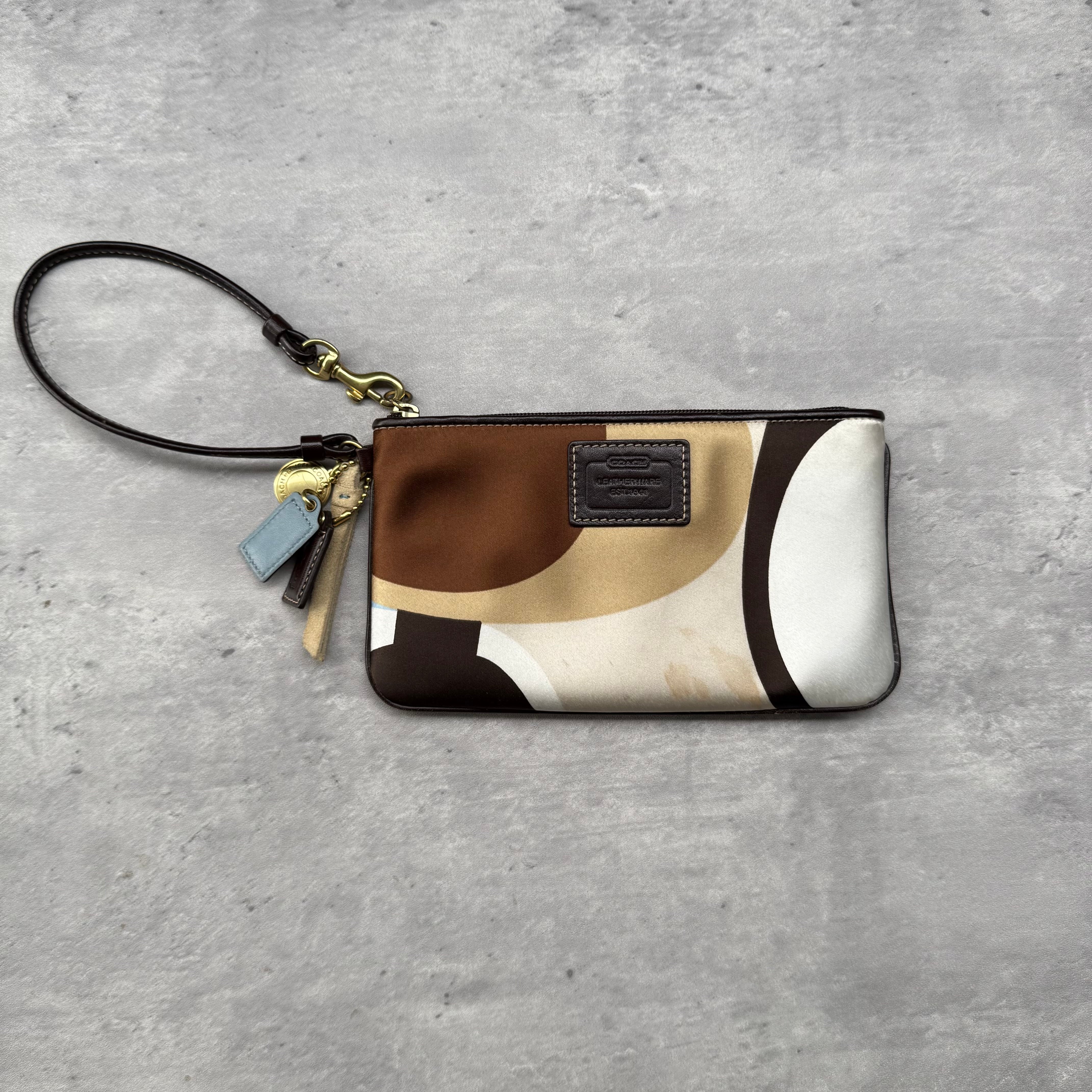 Coach Satin Hampton Wristlet in multicolor satin with abstract brown and beige design, gold-tone hardware, and detachable wrist strap.