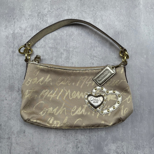 Coach Script Heart Shoulder Bag in beige satin with crystal heart charm, lavender interior, and gold-tone hardware.