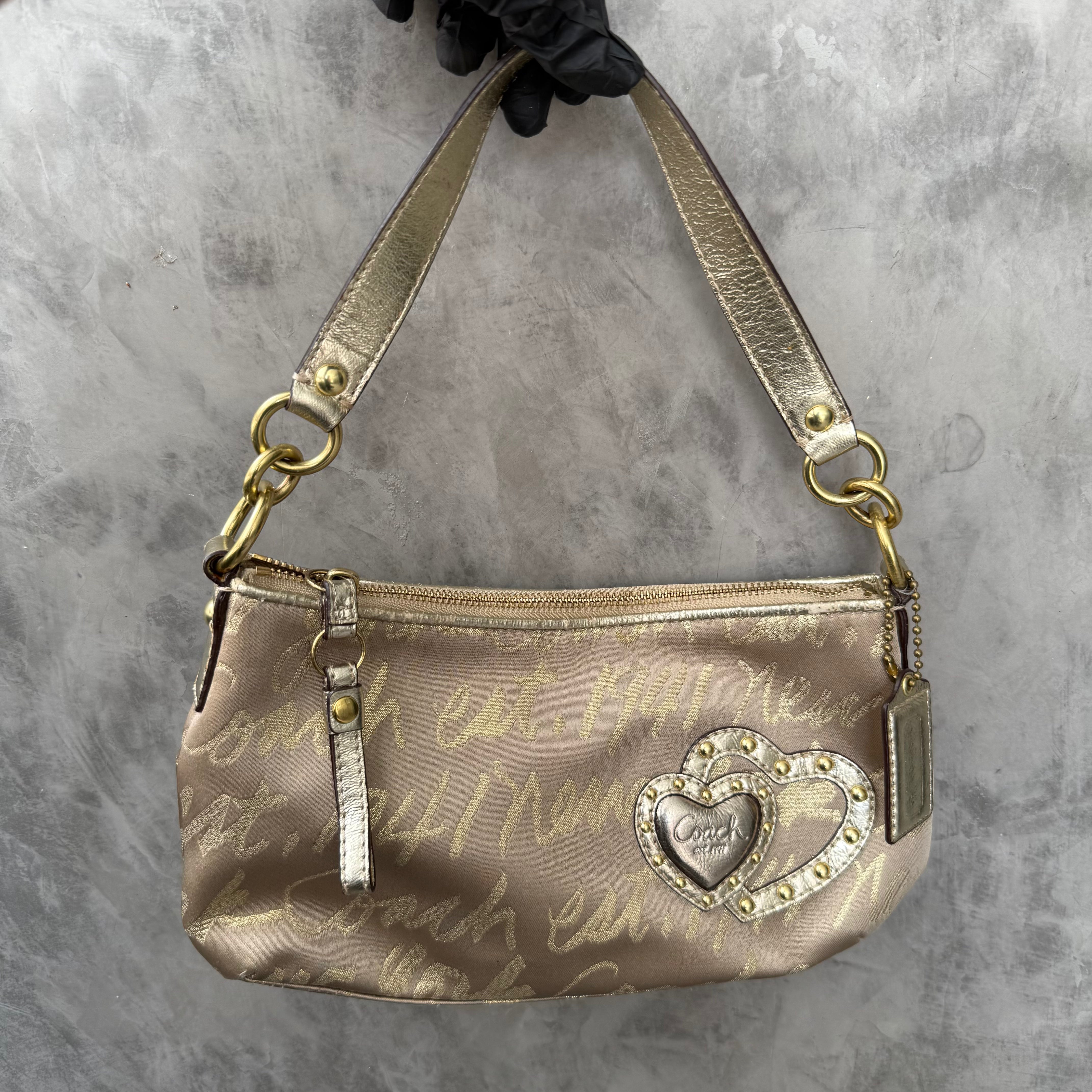 Coach Script Heart Shoulder Bag in beige satin with crystal heart charm, lavender interior, and gold-tone hardware.