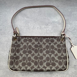 Coach Signature Canvas Charley Crossbody in brown monogram with ivory leather trim, featuring gold hardware and red fabric interior.