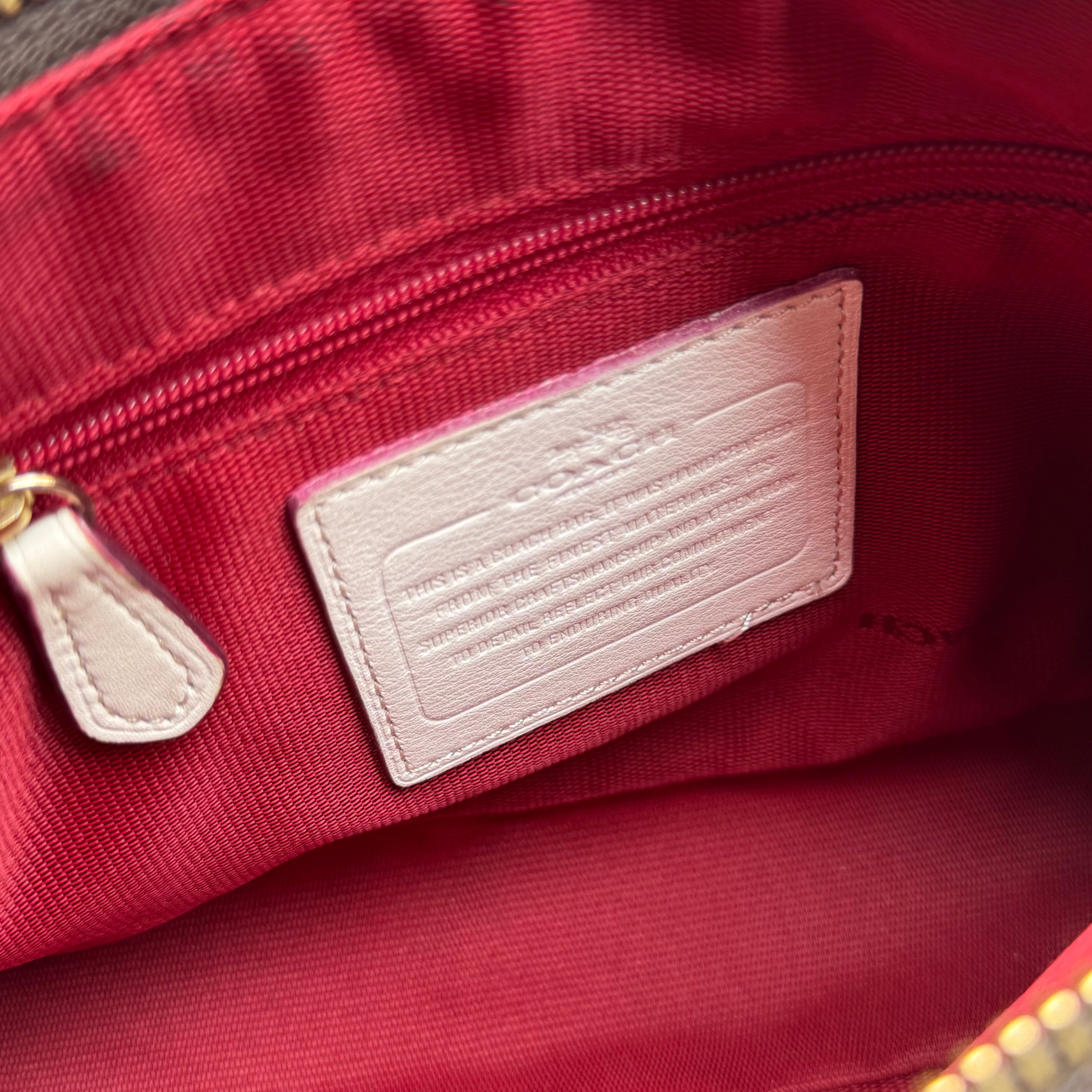 Coach Signature Canvas Charley Crossbody in brown monogram with ivory leather trim, featuring gold hardware and red fabric interior.