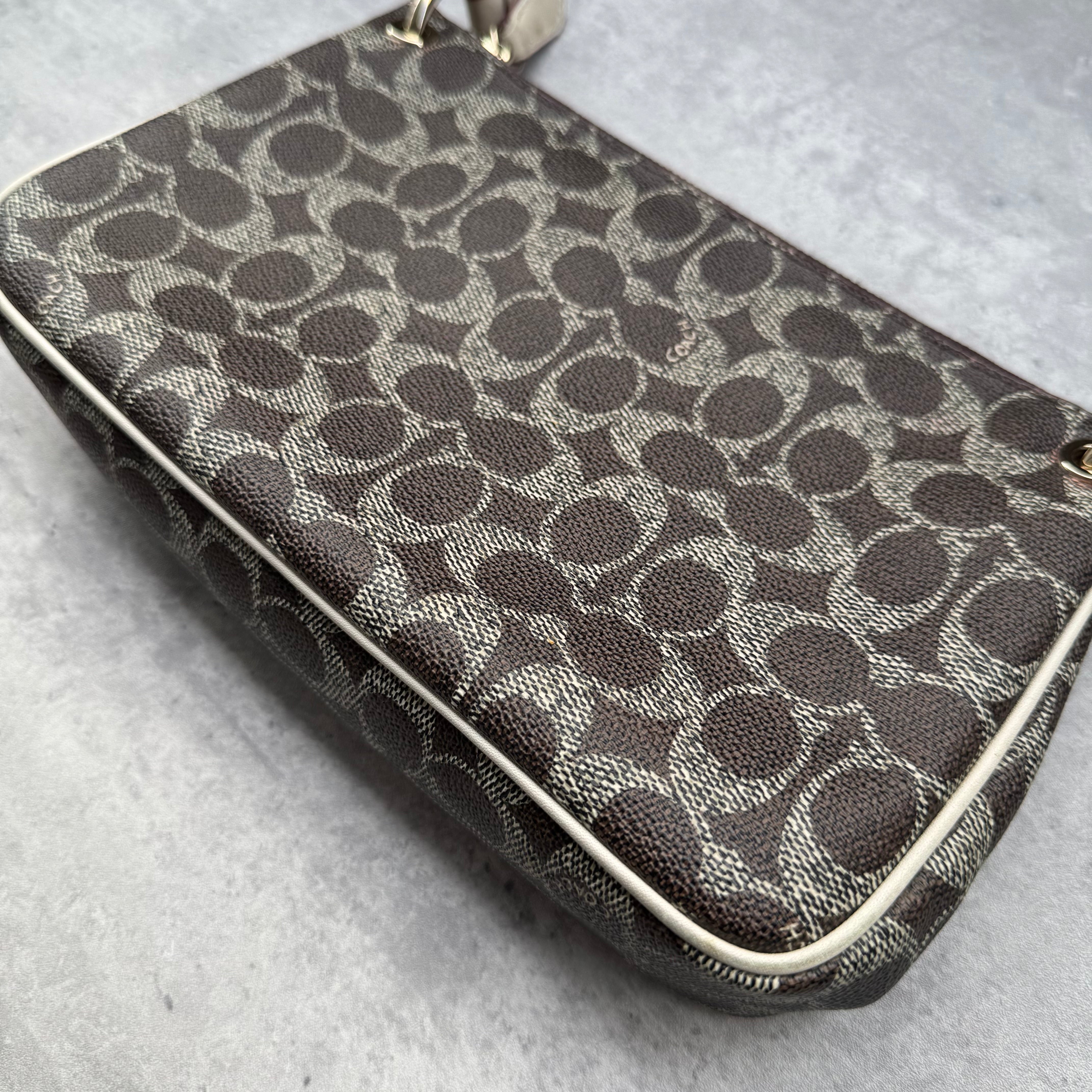 Coach Signature Canvas Charley Crossbody in brown monogram with ivory leather trim, featuring gold hardware and red fabric interior.