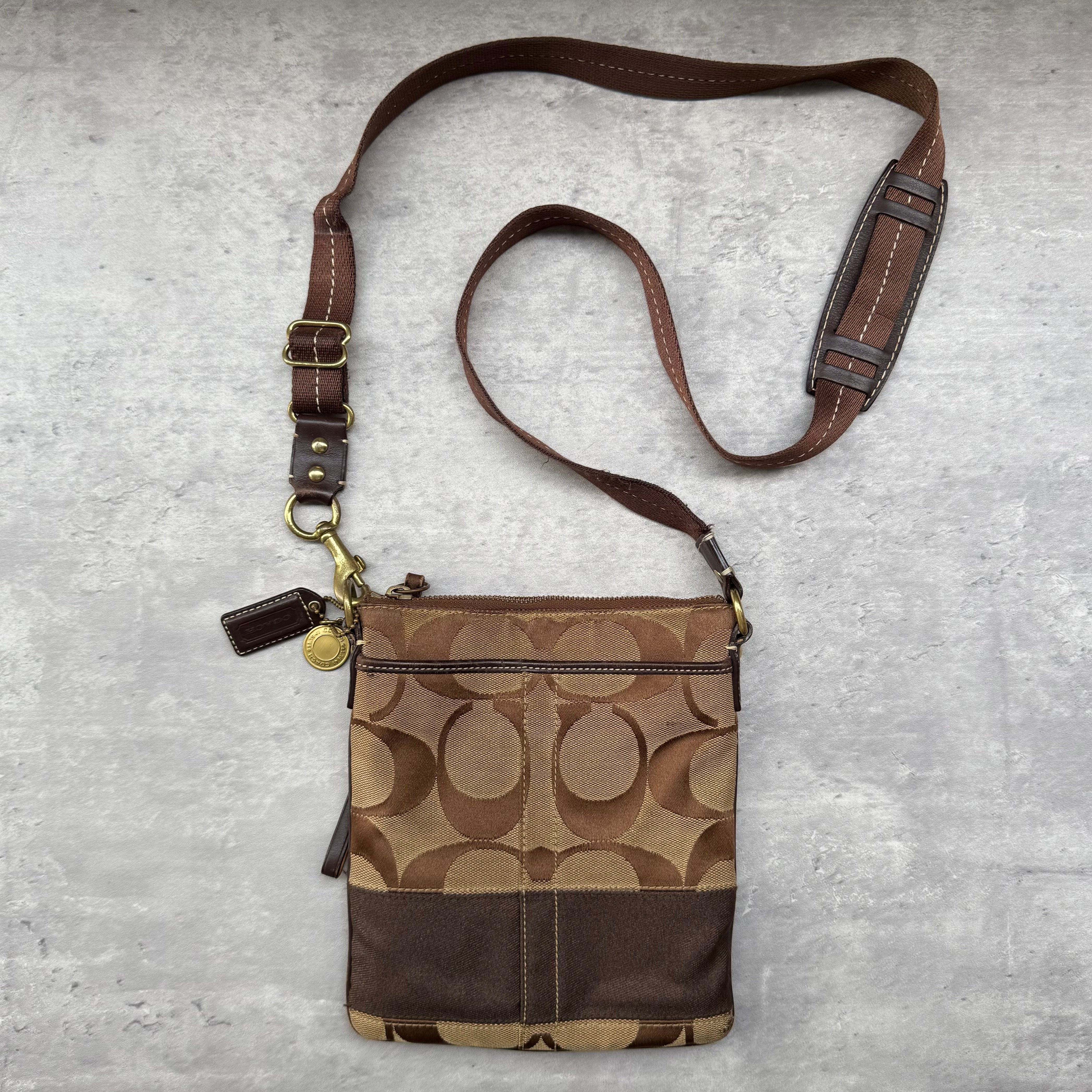 Coach Signature Canvas Crossbody Bag in brown with monogram design, zip closure, and adjustable strap