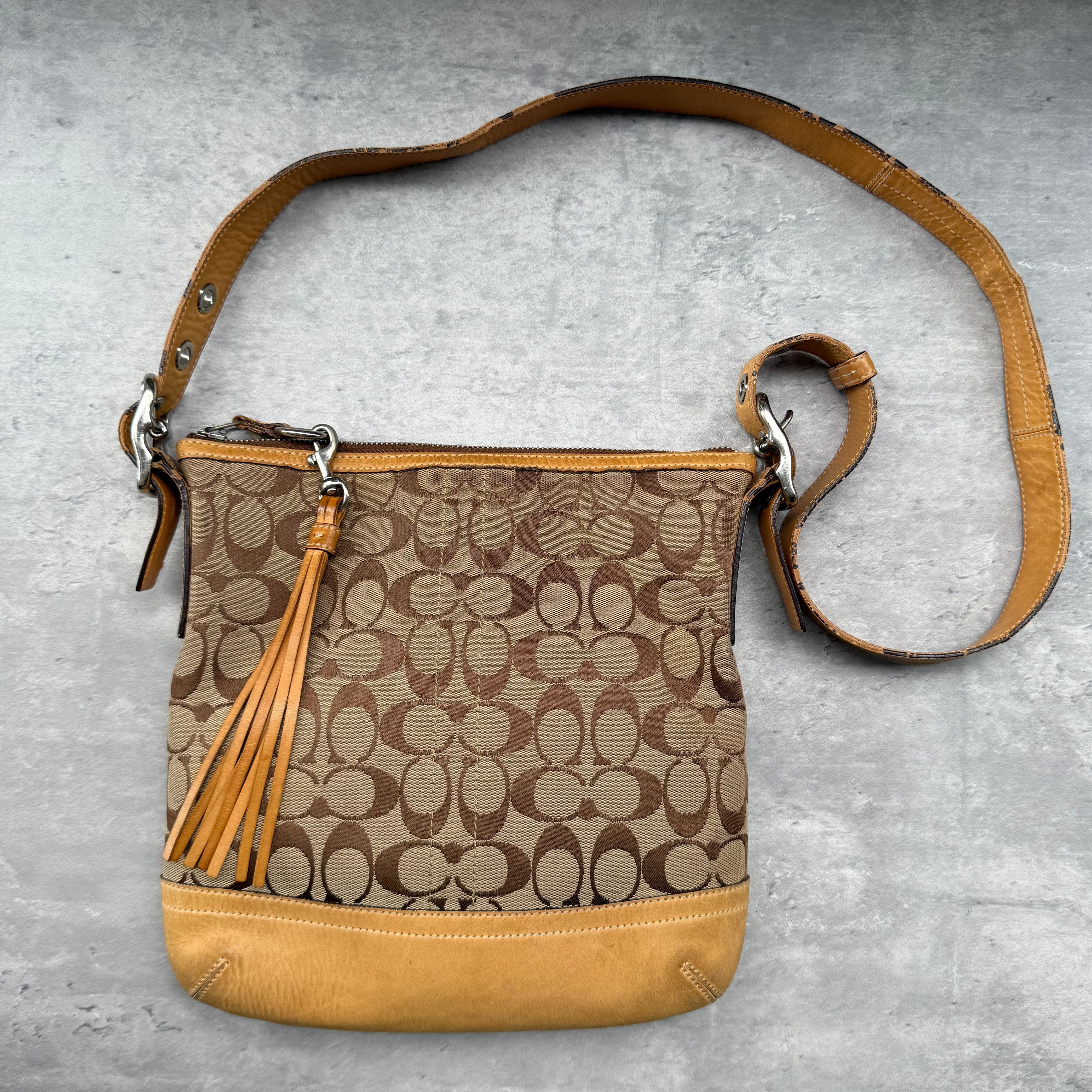 Coach Signature Canvas Crossbody Shoulder Bag in beige and brown with leather trim, tassel detail, and adjustable strap