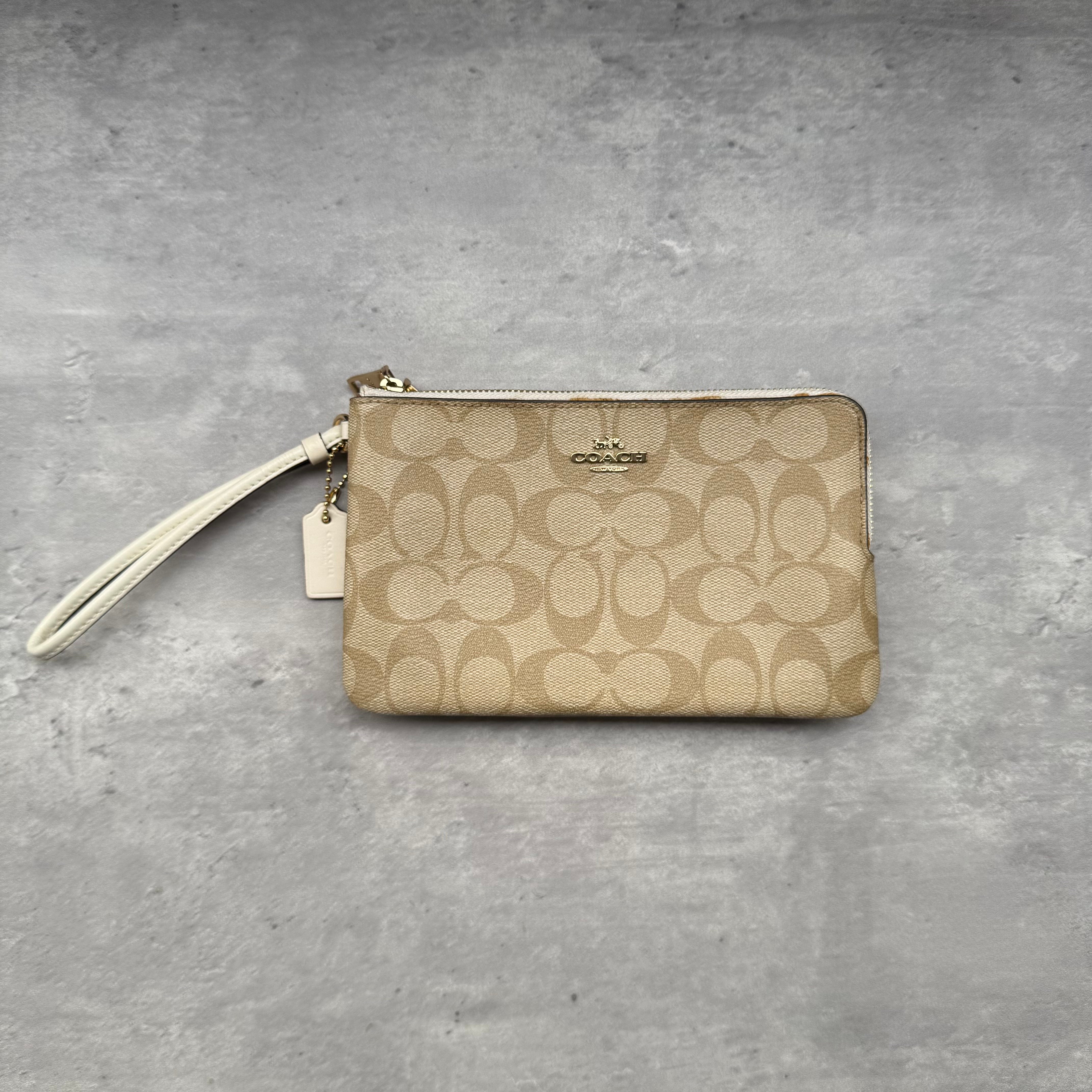 Coach Signature Canvas Double Zip Wristlet in cream, crafted from jacquard canvas with leather trim and gold-tone hardware.