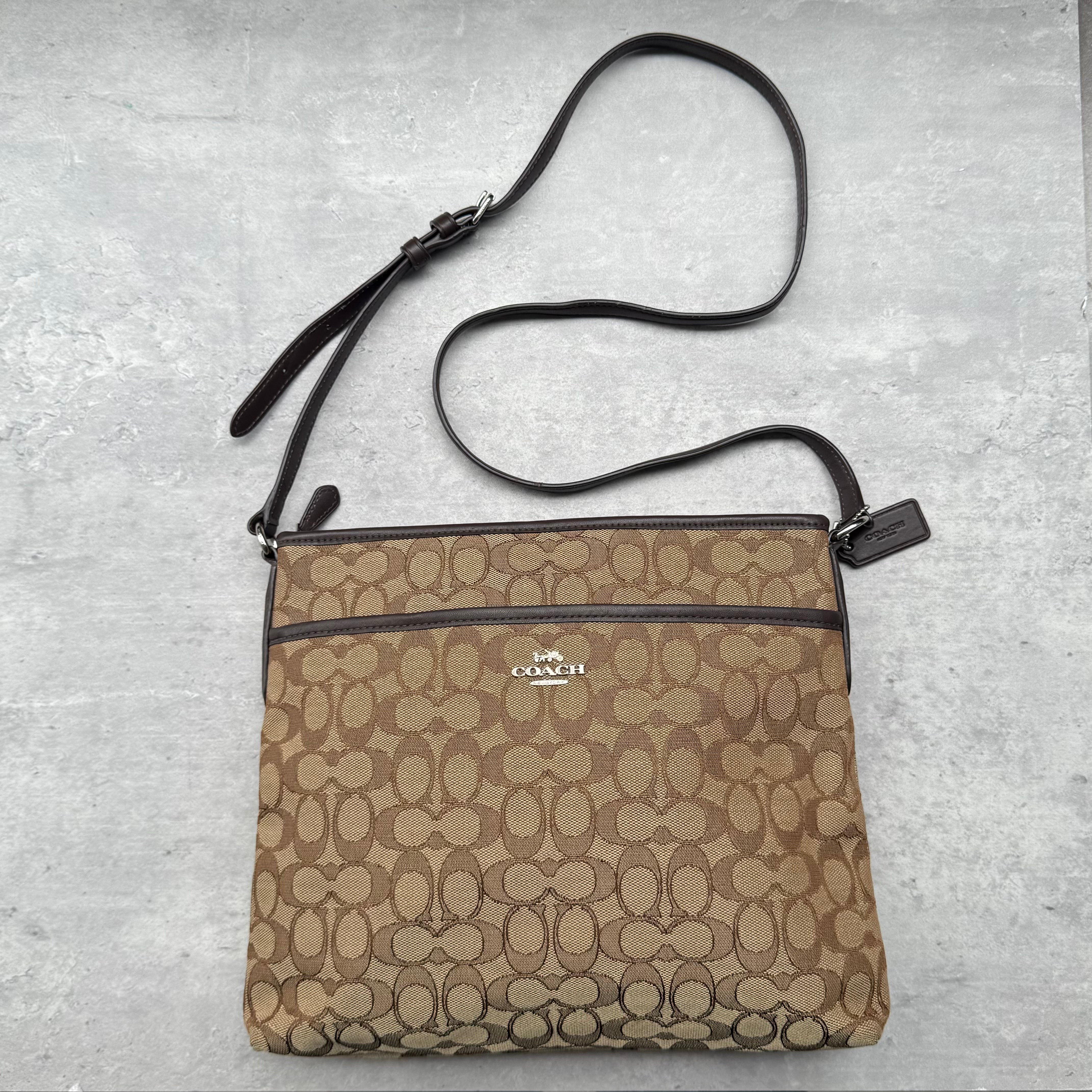 Coach Signature Canvas File Crossbody Bag in beige with brown leather trim and silver-tone hardware.
