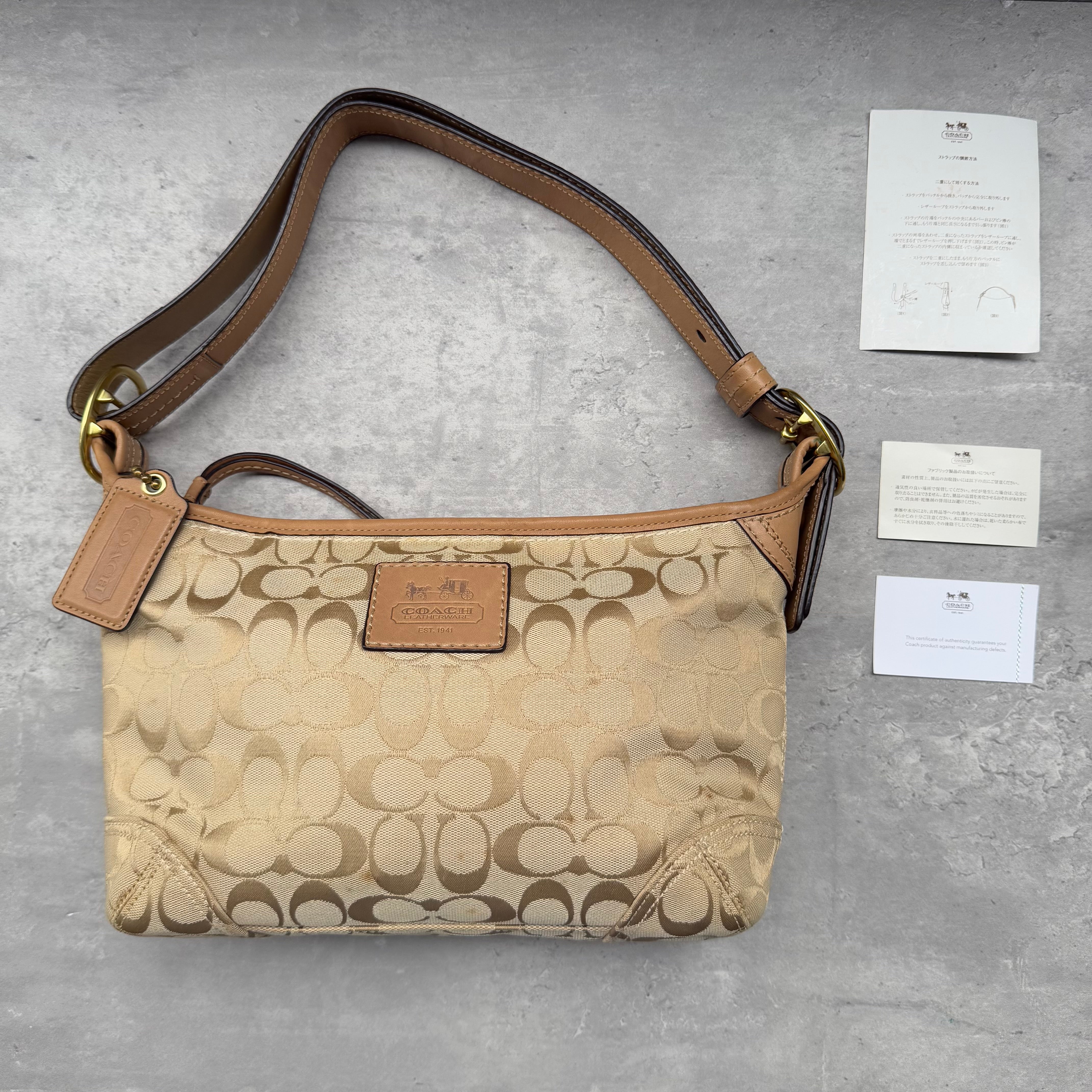 Coach Signature Canvas Hobo Crossbody Shoulder Bag in beige jacquard with tan leather trim, gold-tone hardware, and purple interior lining.