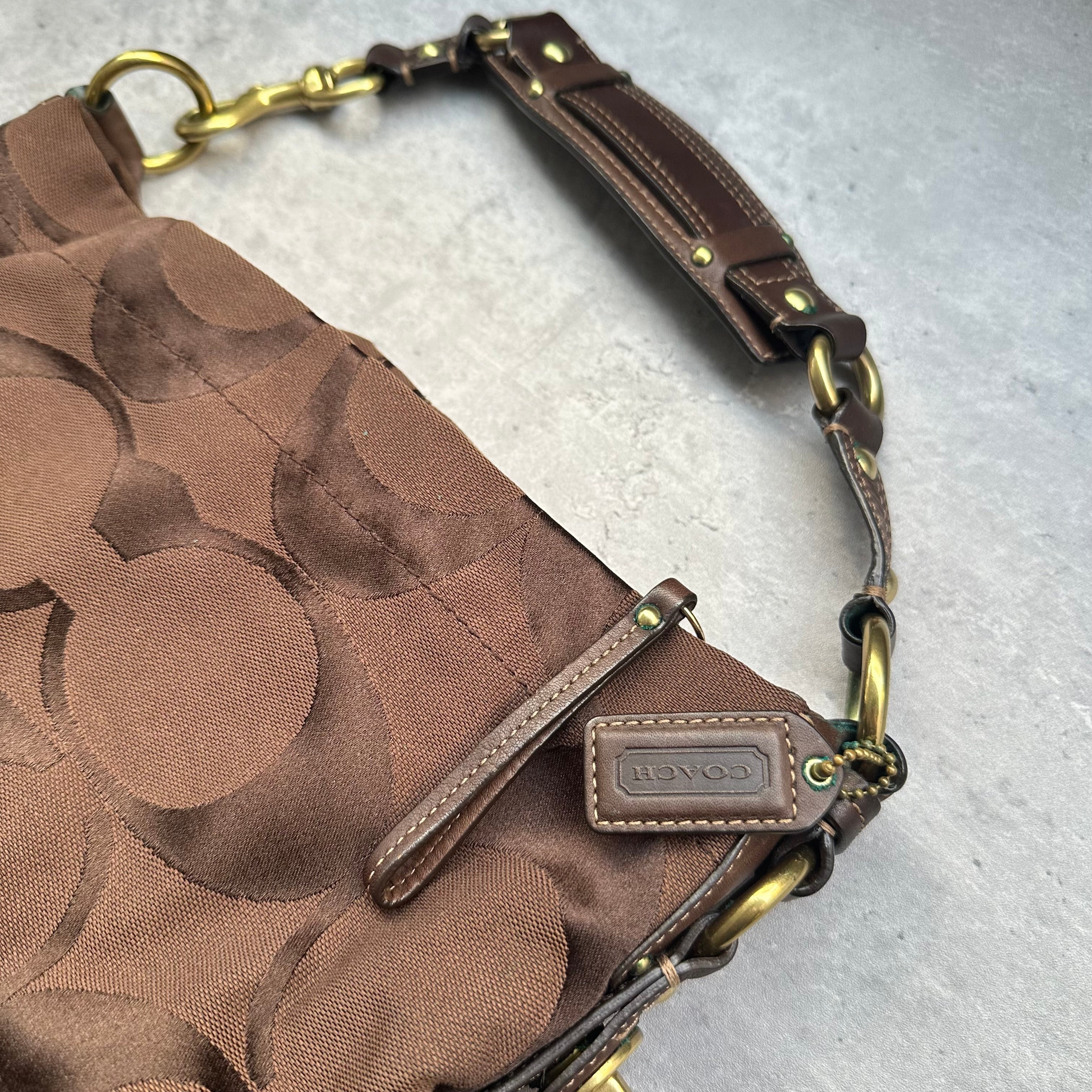 Coach Signature Canvas Hobo Shoulder Bag in brown jacquard fabric, featuring brass hardware, leather trim, and a zip-top closure.